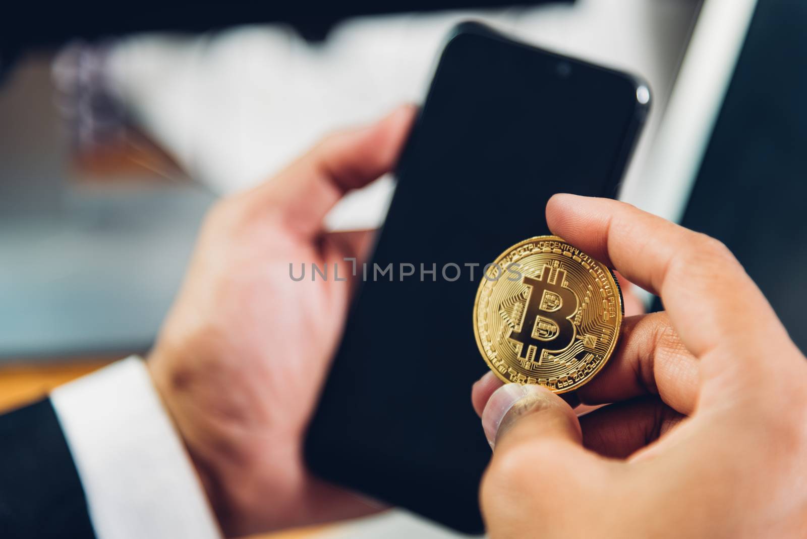 Business man hand holding crypto bitcoin currency money on smart mobile phone, finance concept