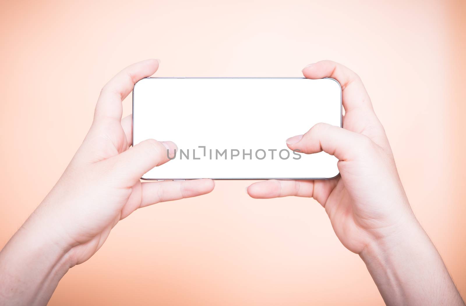 Female hand holding mobile smartphone play game gamer blank white screen on orange background