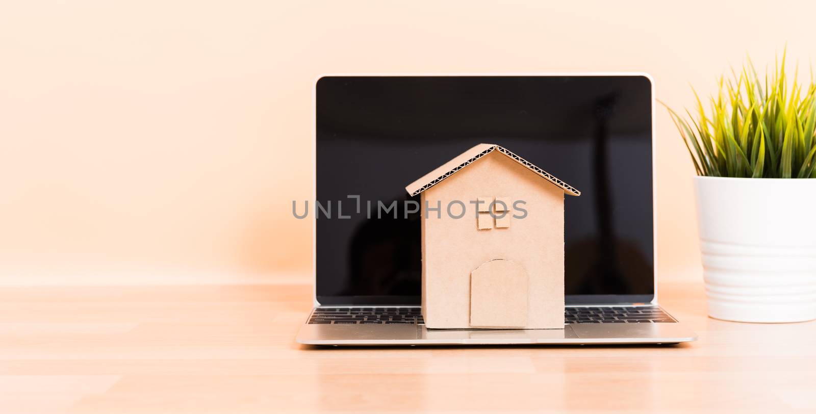 Cardboard paper model house and computer laptop by Sorapop