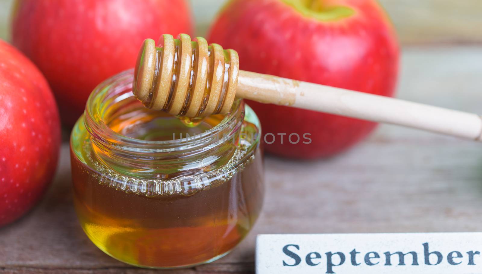 Jewish holiday, Apples Rosh Hashanah on the photo have honey in jar and red apples on wooden background
