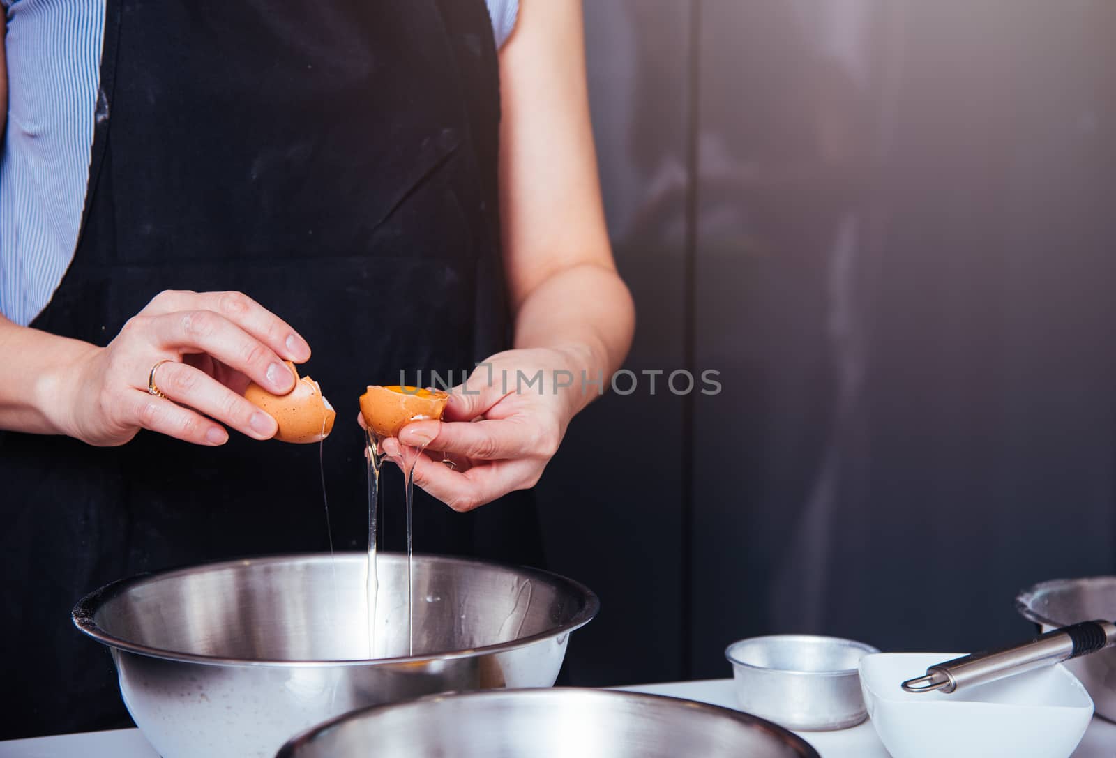 Woman girl baker in kitchen cooking whisk egg to bowl for bakery cake
