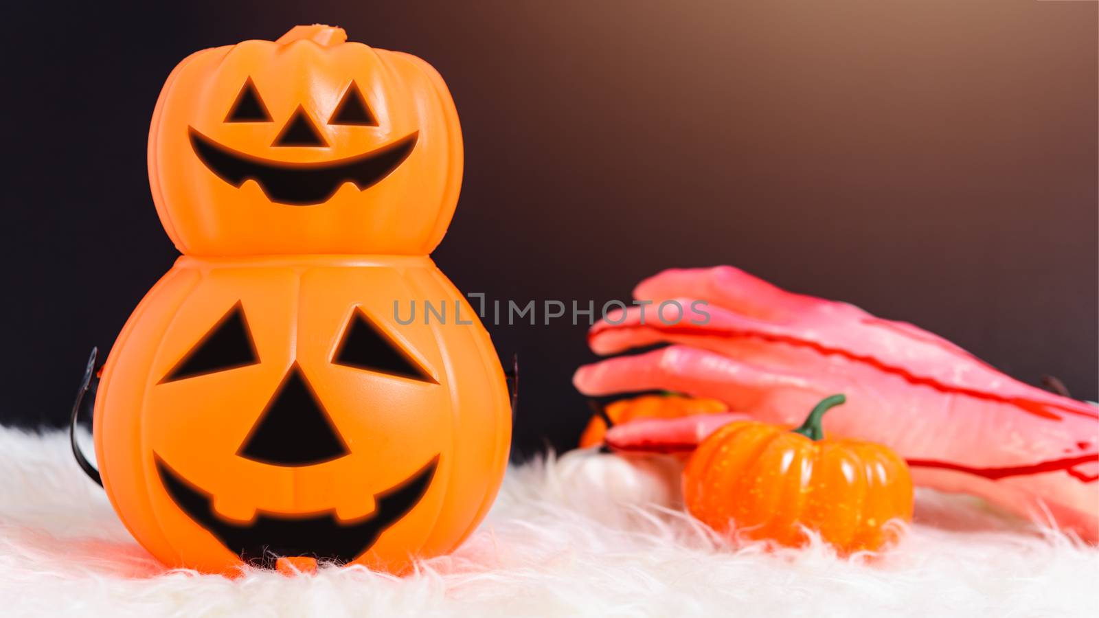 Stack Pumpkin Jack creepy and hand with blood in Halloween day concept on black background