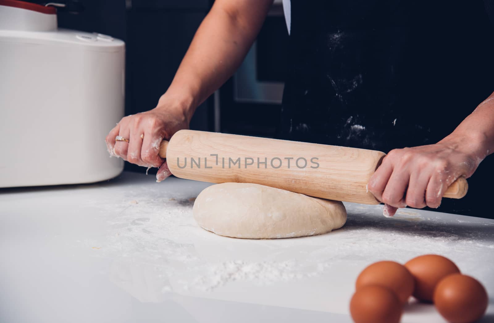 Hand of woman making dough with rolling wooden  by Sorapop