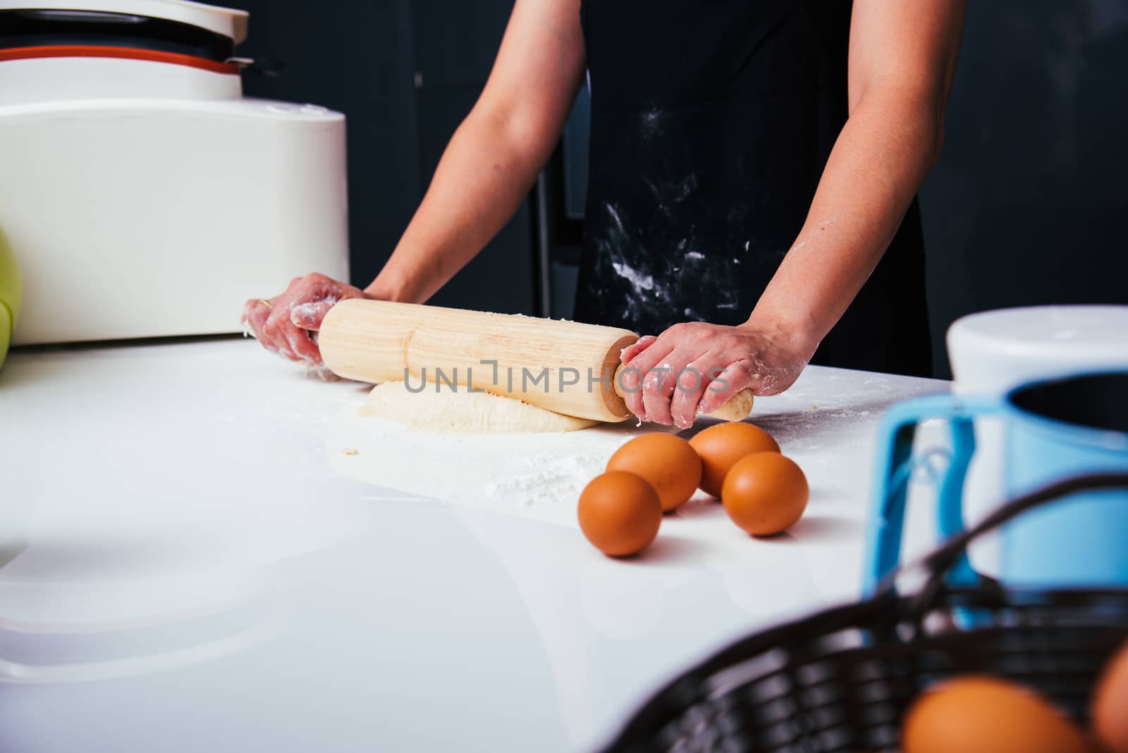 Hands of woman making dough with rolling wooden  by Sorapop