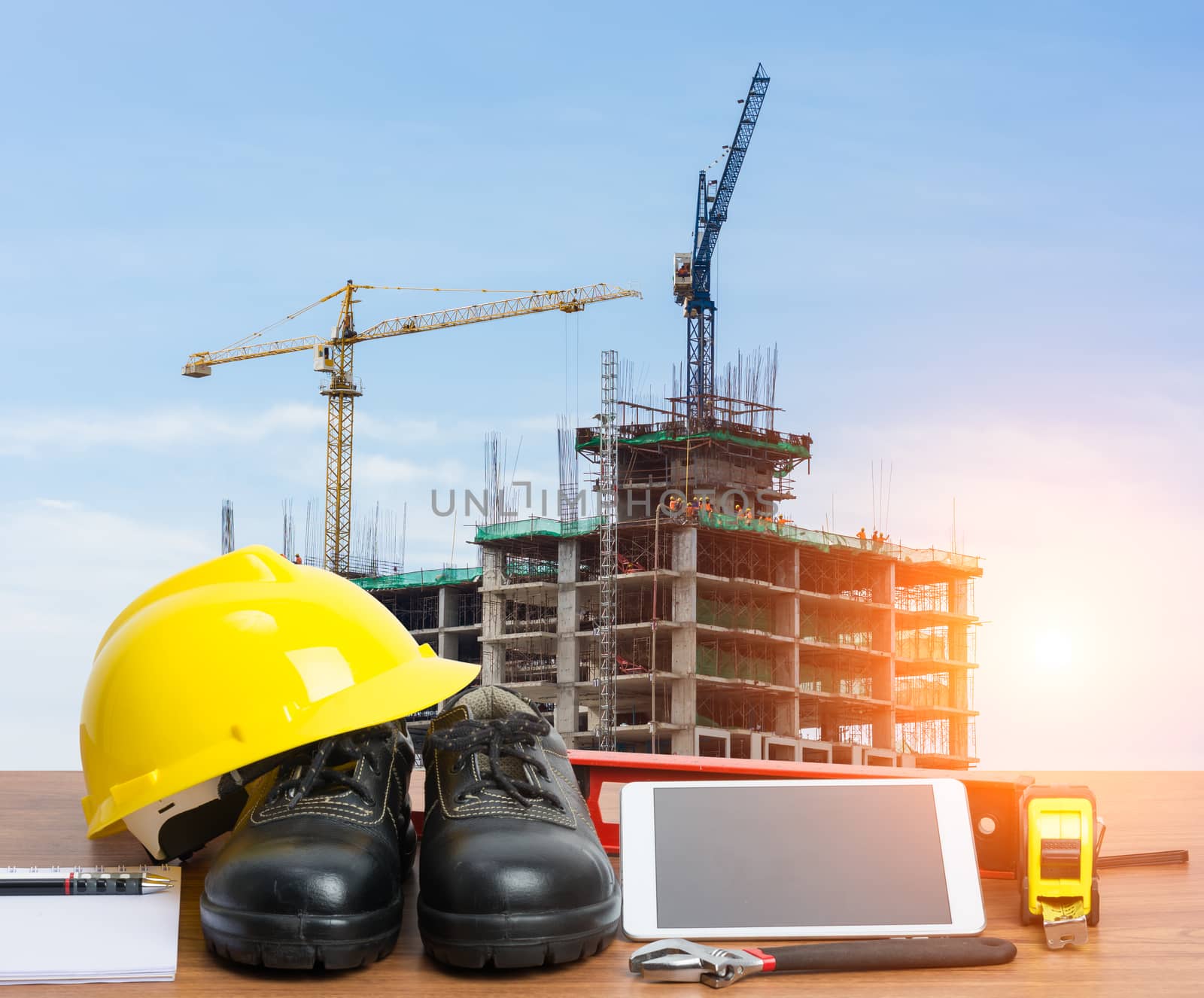 Working table engineer with tablet and tools in building construction crane