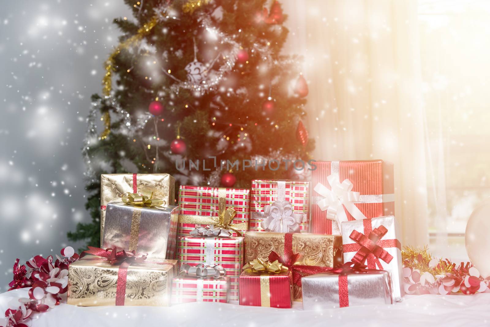 Many Christmas presents gift boxes on a table with Christmas tre by Sorapop