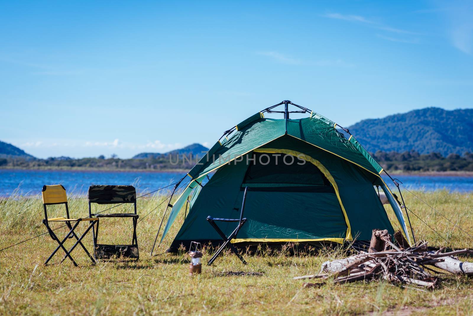 Camping green tent near lake by Sorapop