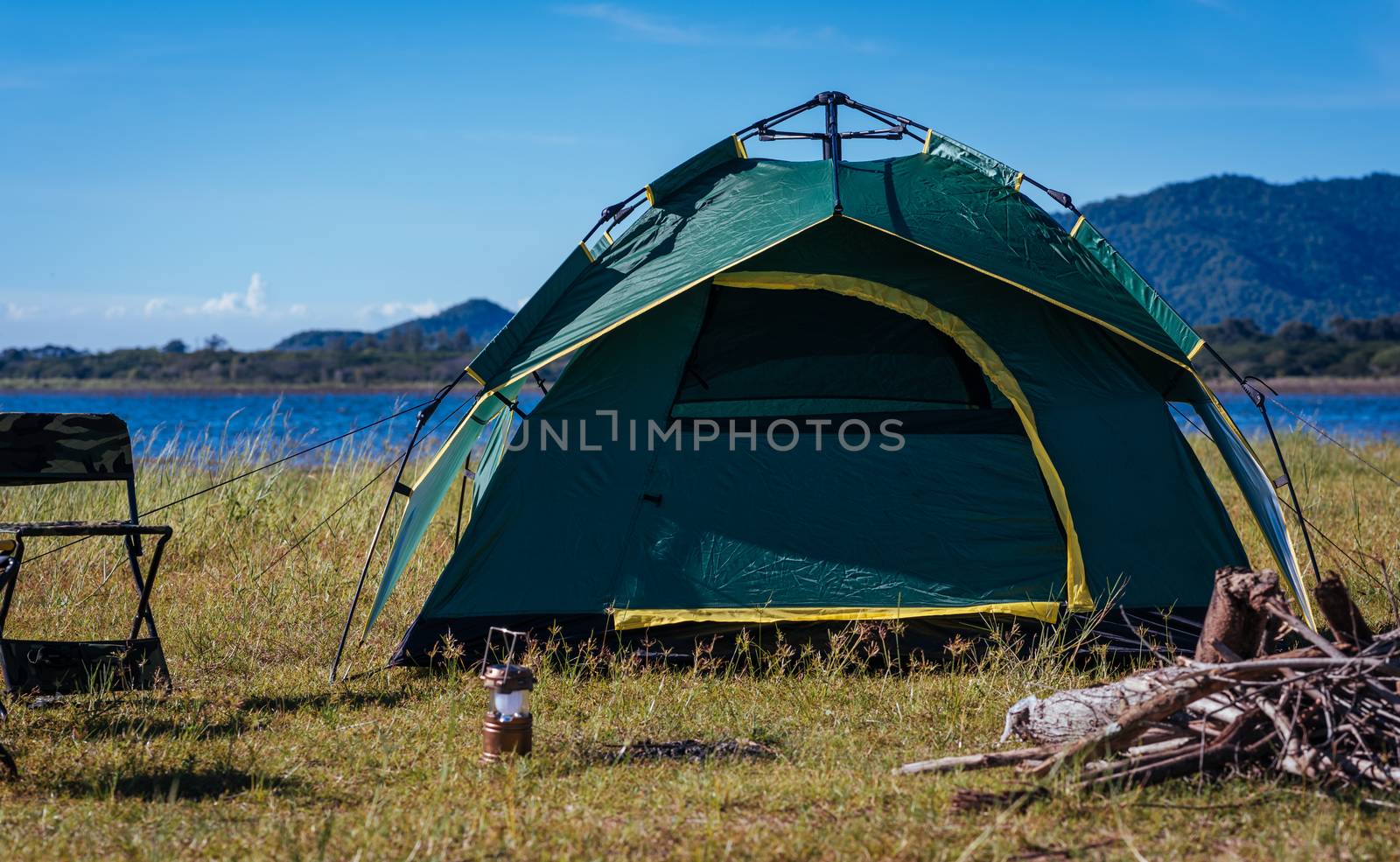 Camping green tent near lake by Sorapop