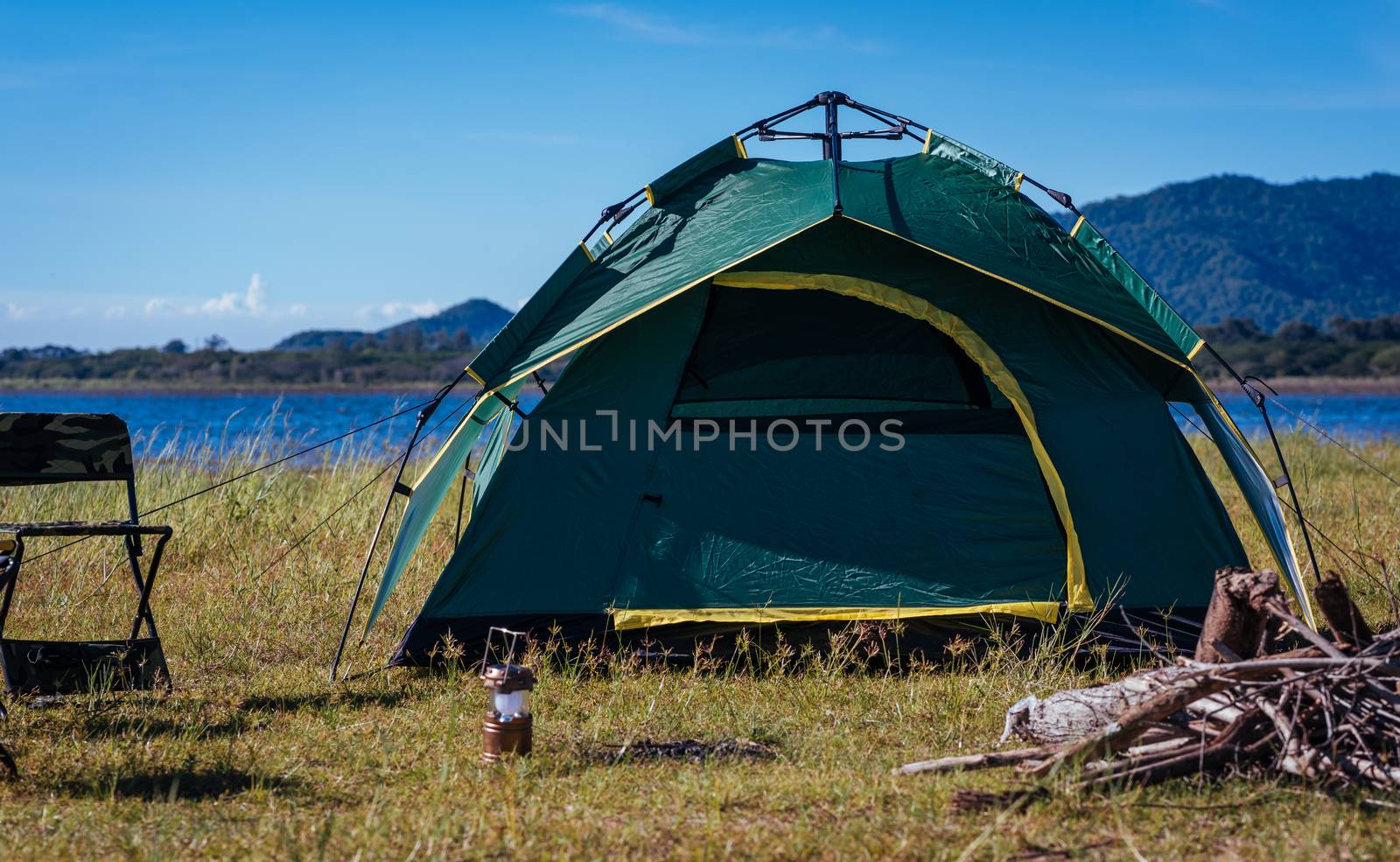 Camping green tent near lake, no people