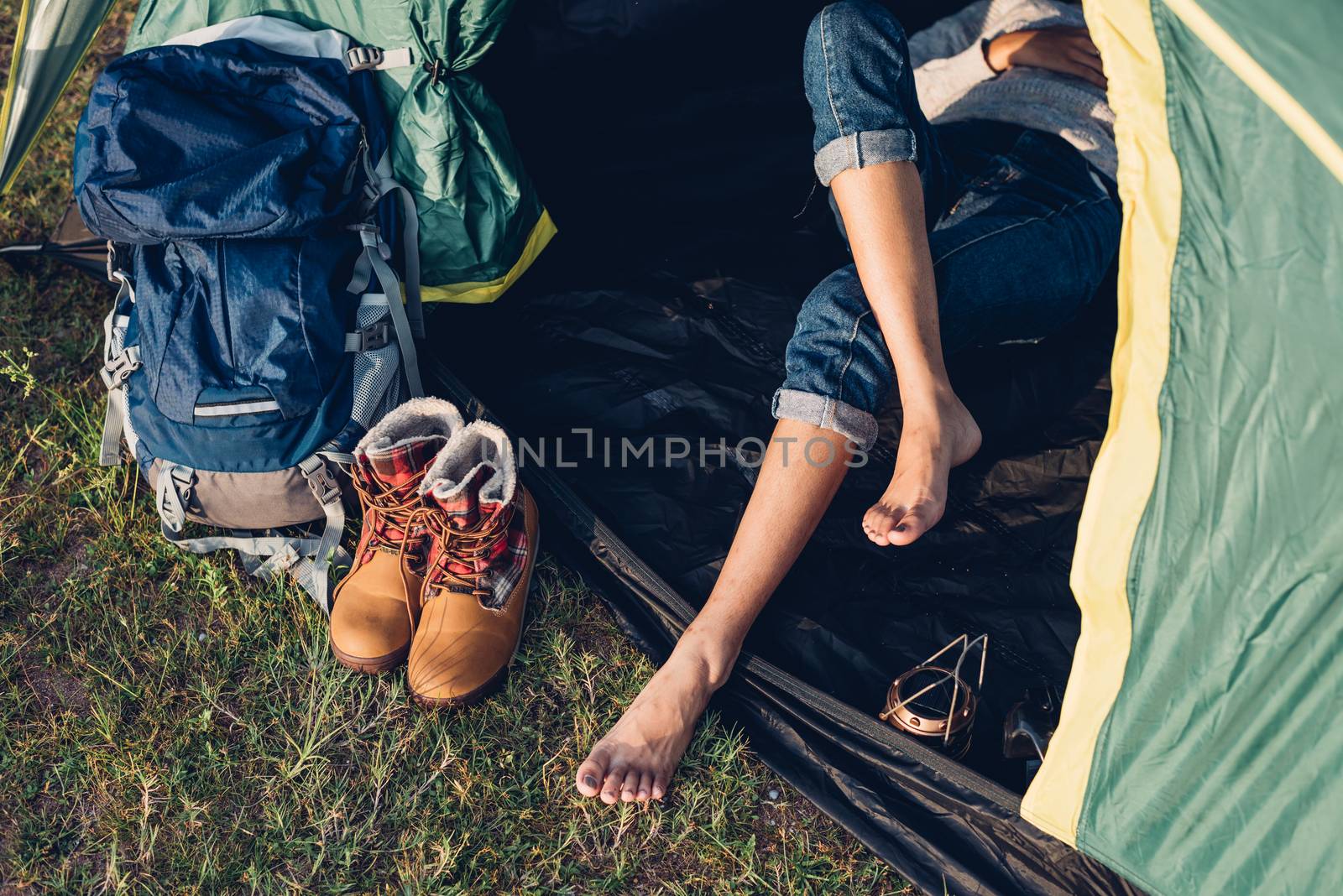 Legs of young woman inside camping tent  by Sorapop