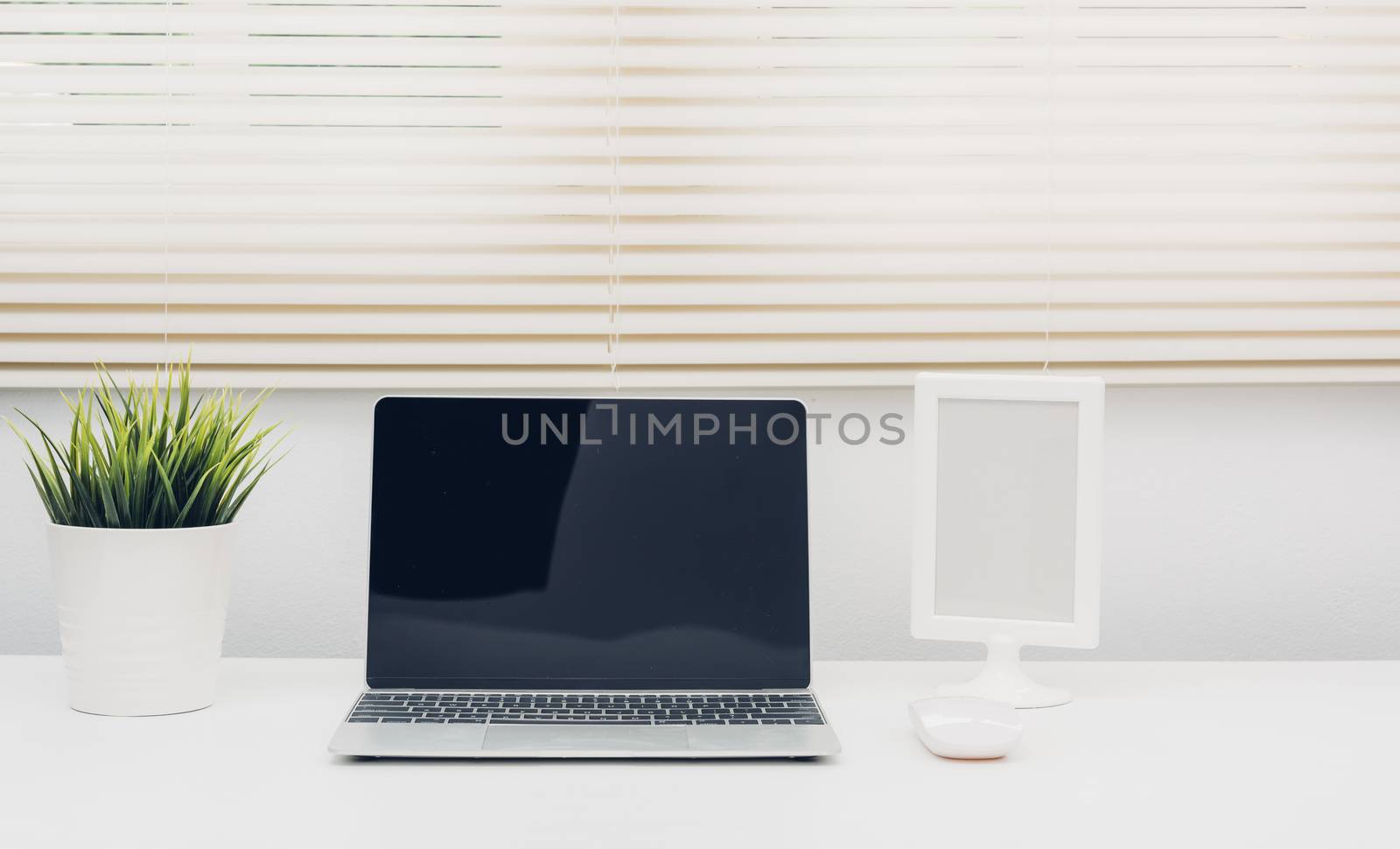 Laptop computer blank screen on white desk in office home