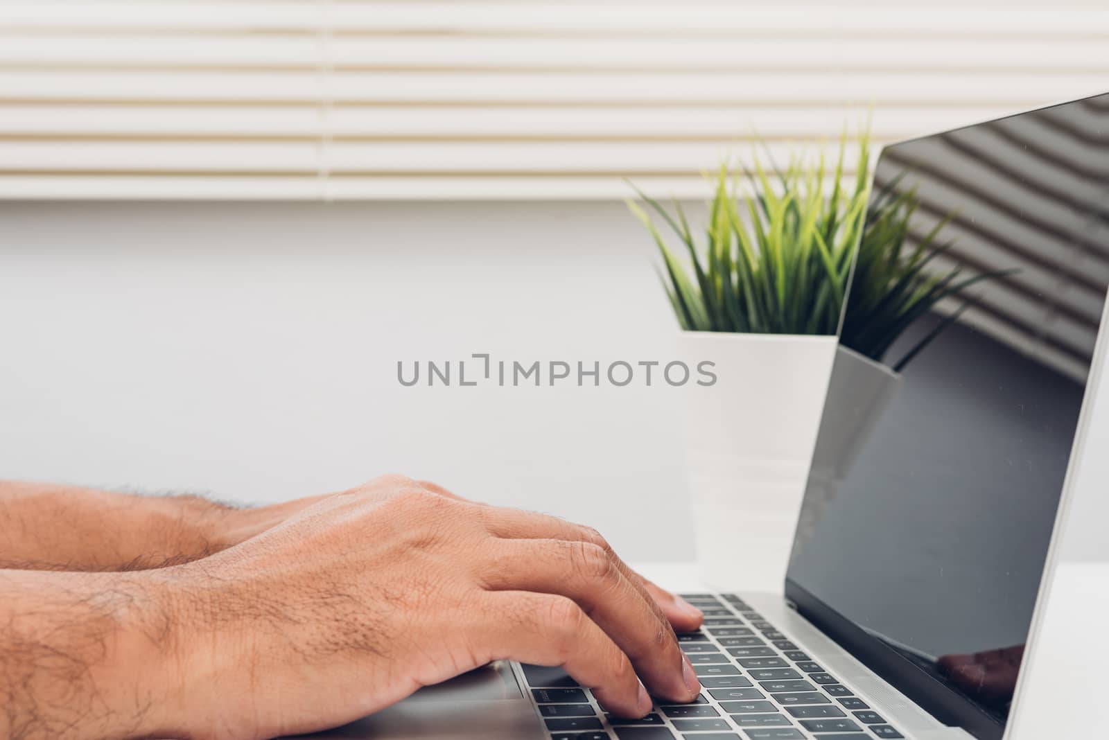 Hands of male businessmen Using keyboard on laptop computer in home office