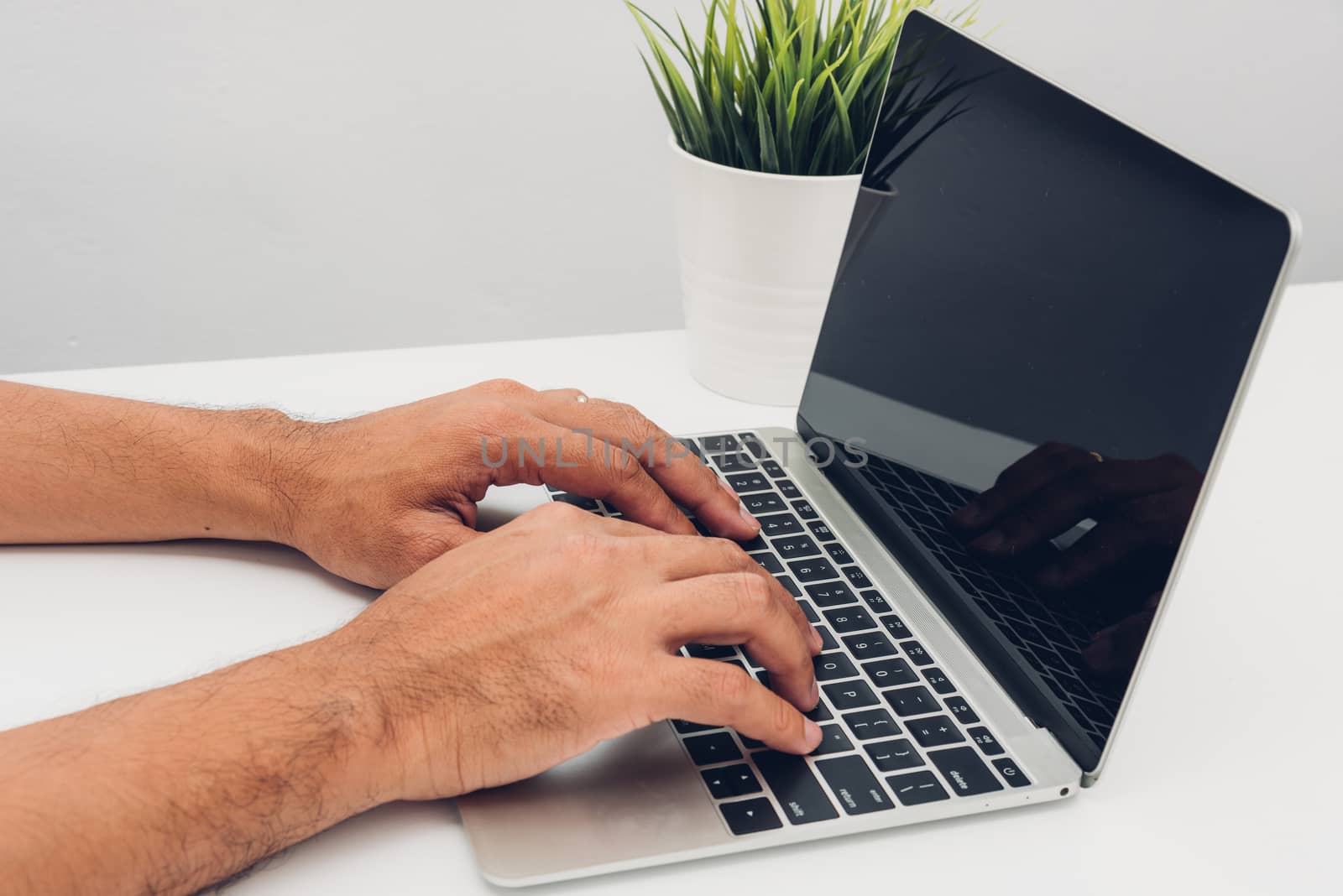 Hands of male businessmen Using keyboard on laptop computer in home office