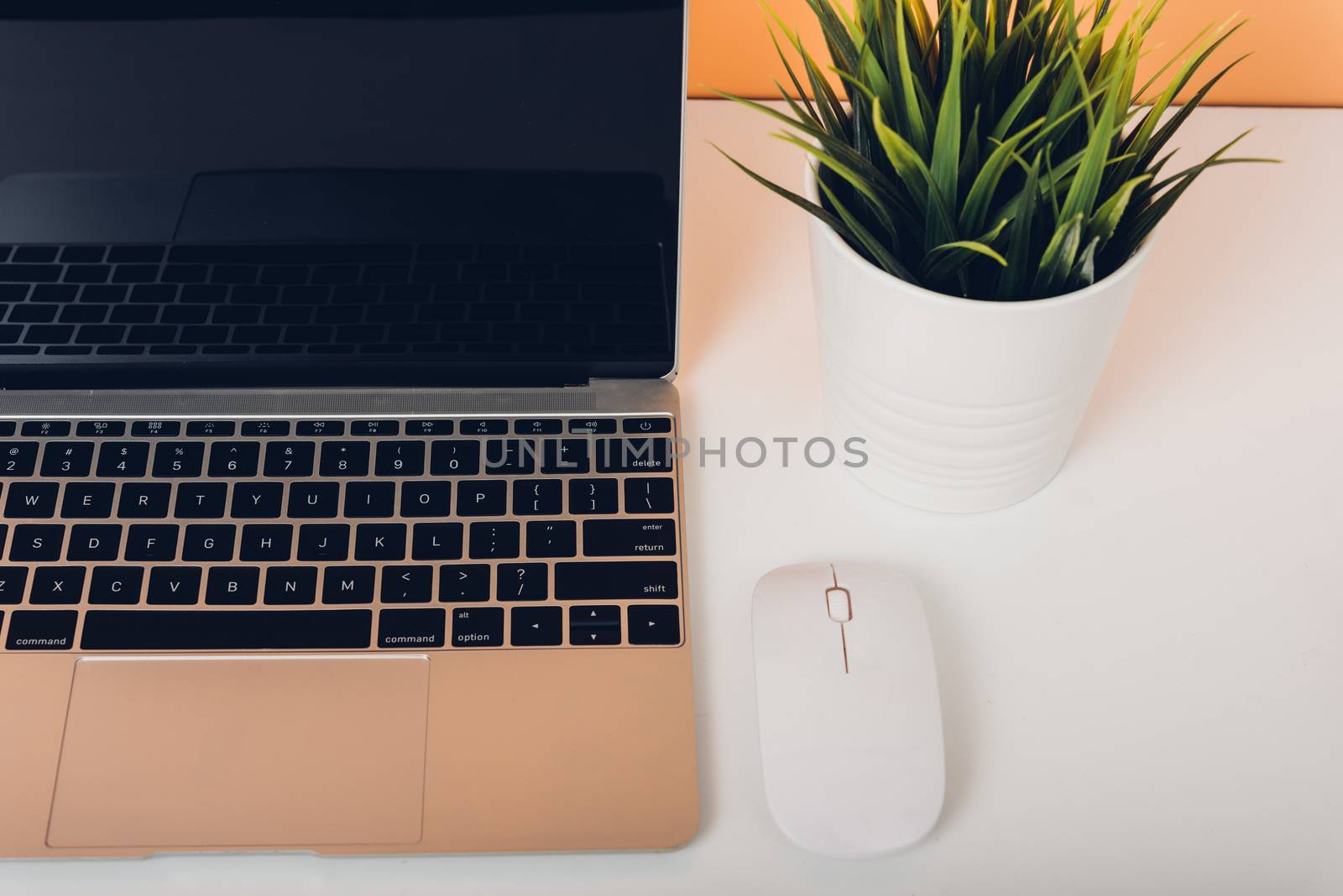Mock up laptop notebook computer on desk table office soft yellow wall and blank screen