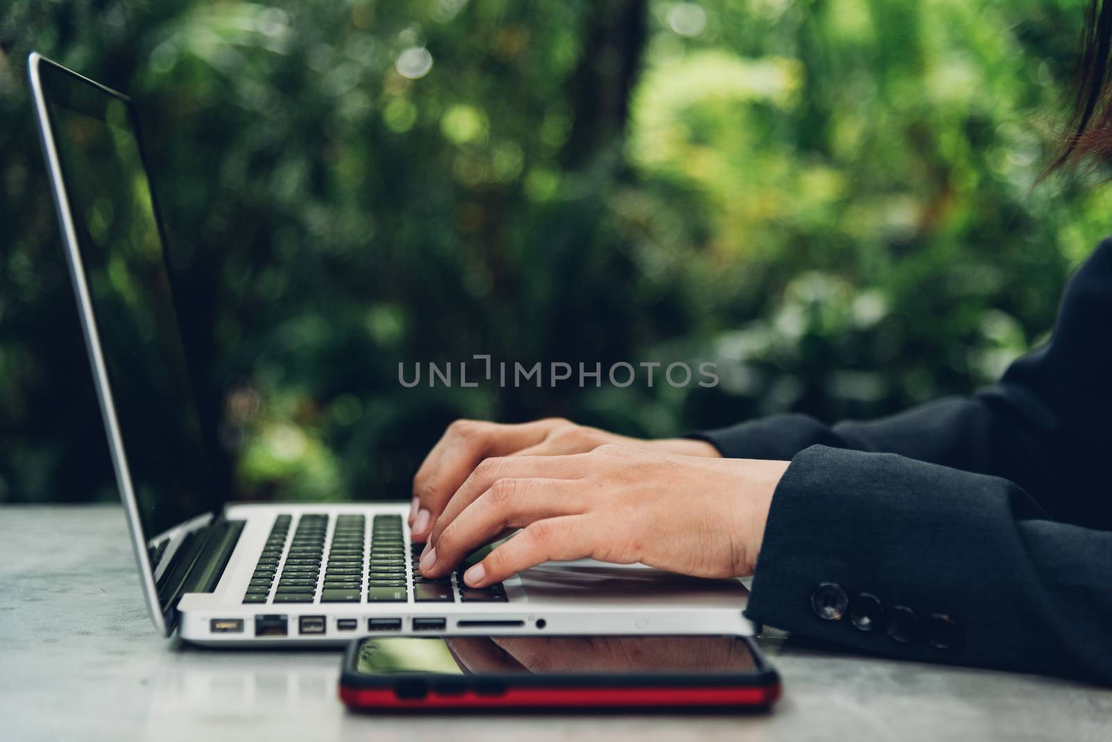 Business woman using his computer laptop on The desk is surrounded by nature
