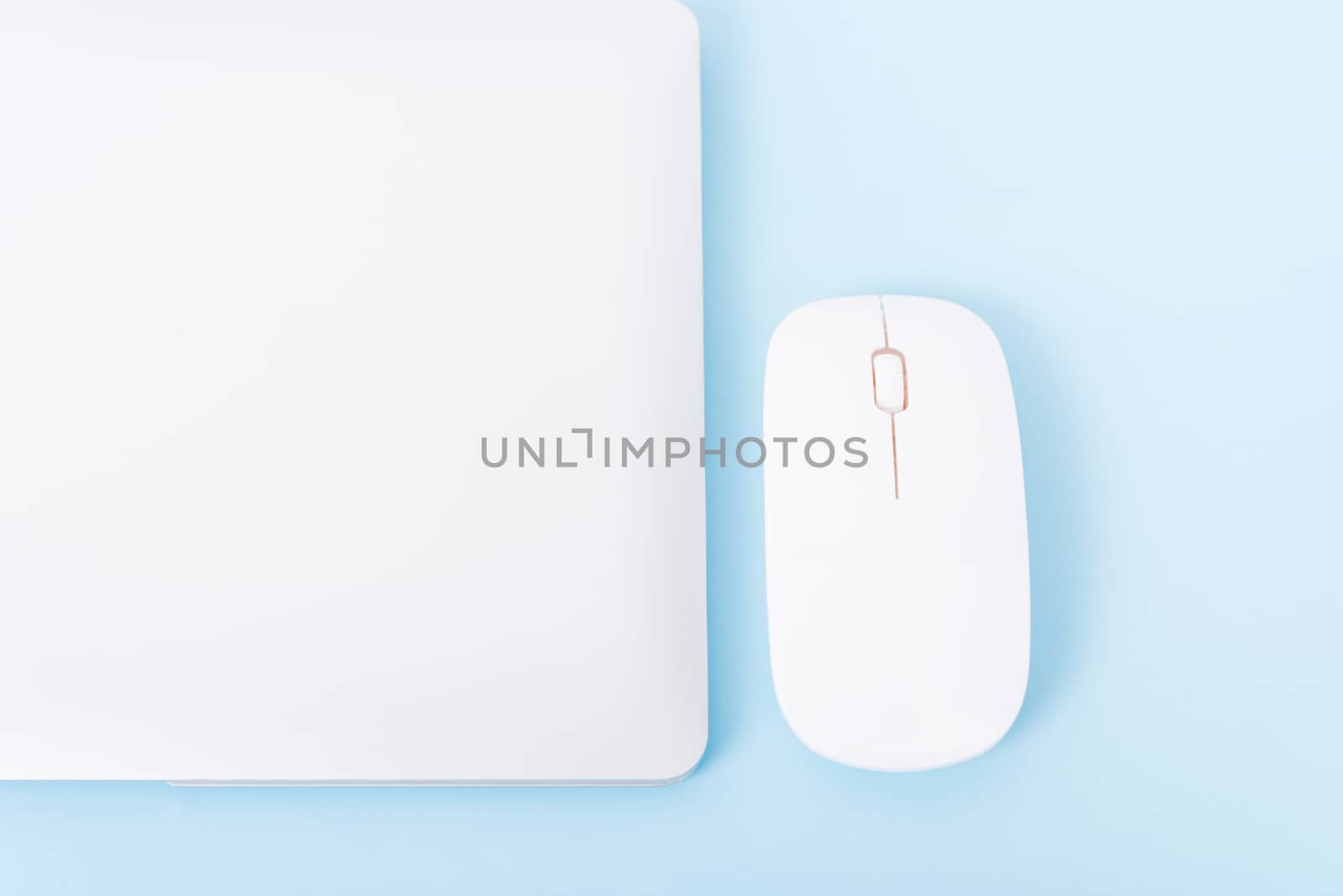 Top view close cover laptop computer notebook and wireless mouse isolated on blue background