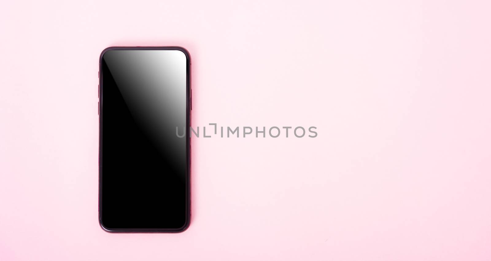 Top view of modern technology smart phone mobile on pink background with copy space