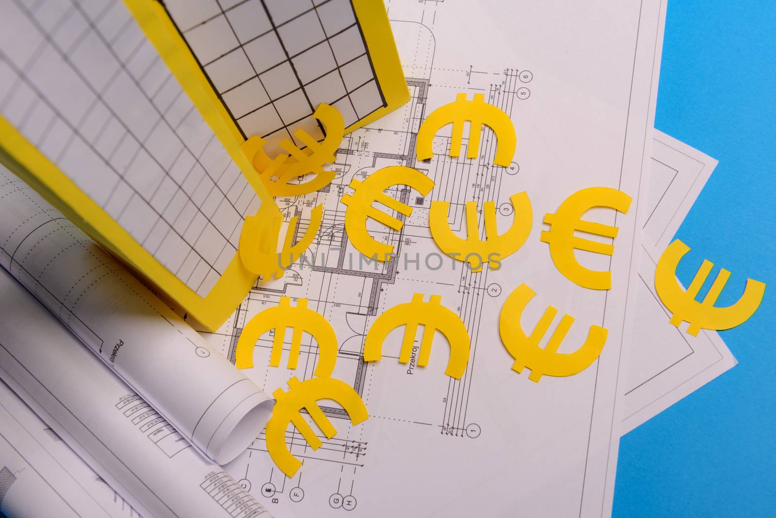 Paper skyscrapers , euro money, house projects plan and blueprints on blue background paper. Minimalistic and simple concept, style. Horizontal orientation. View from above.