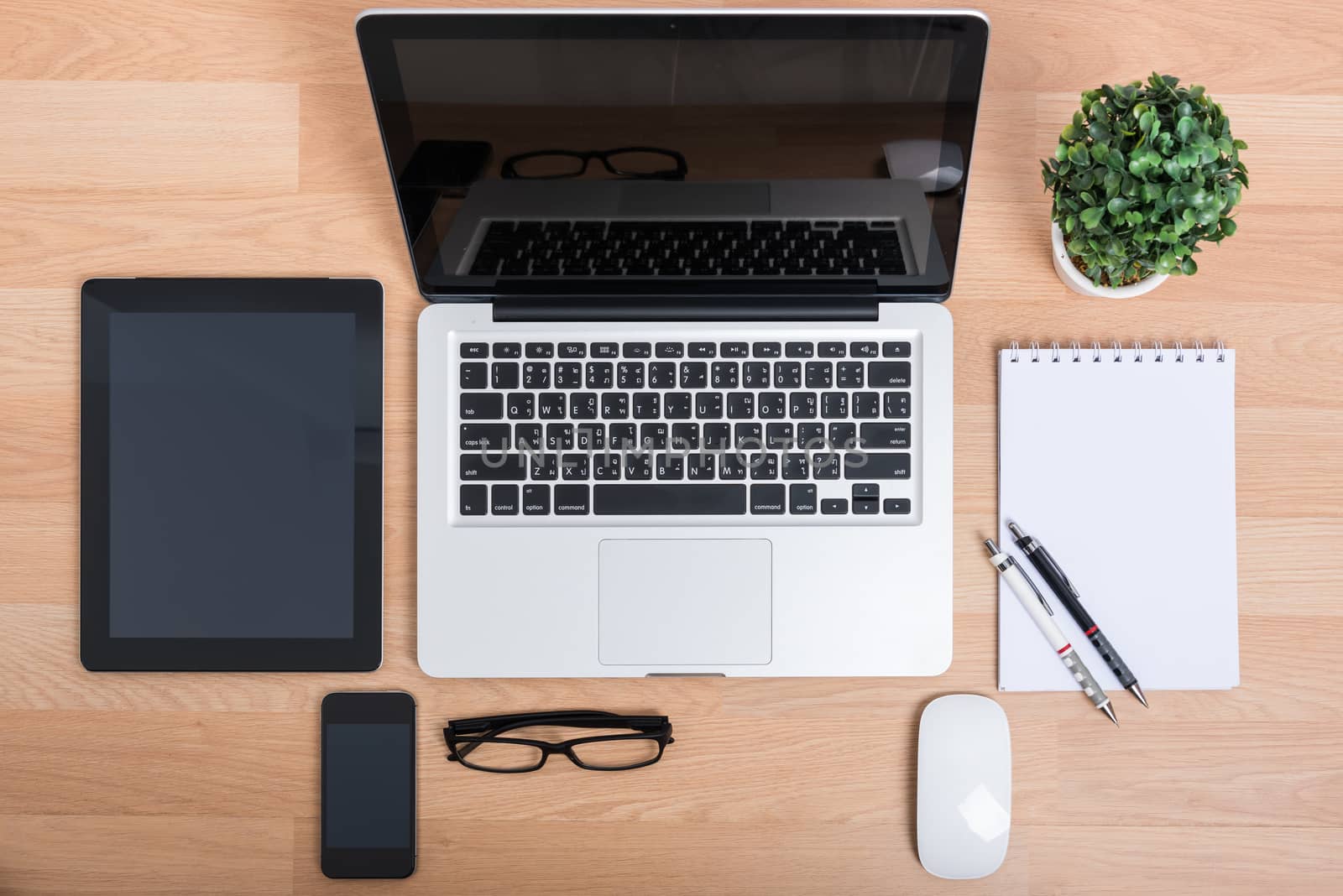 Top view open laptop with digital tablet and white smartphone on wooden desk