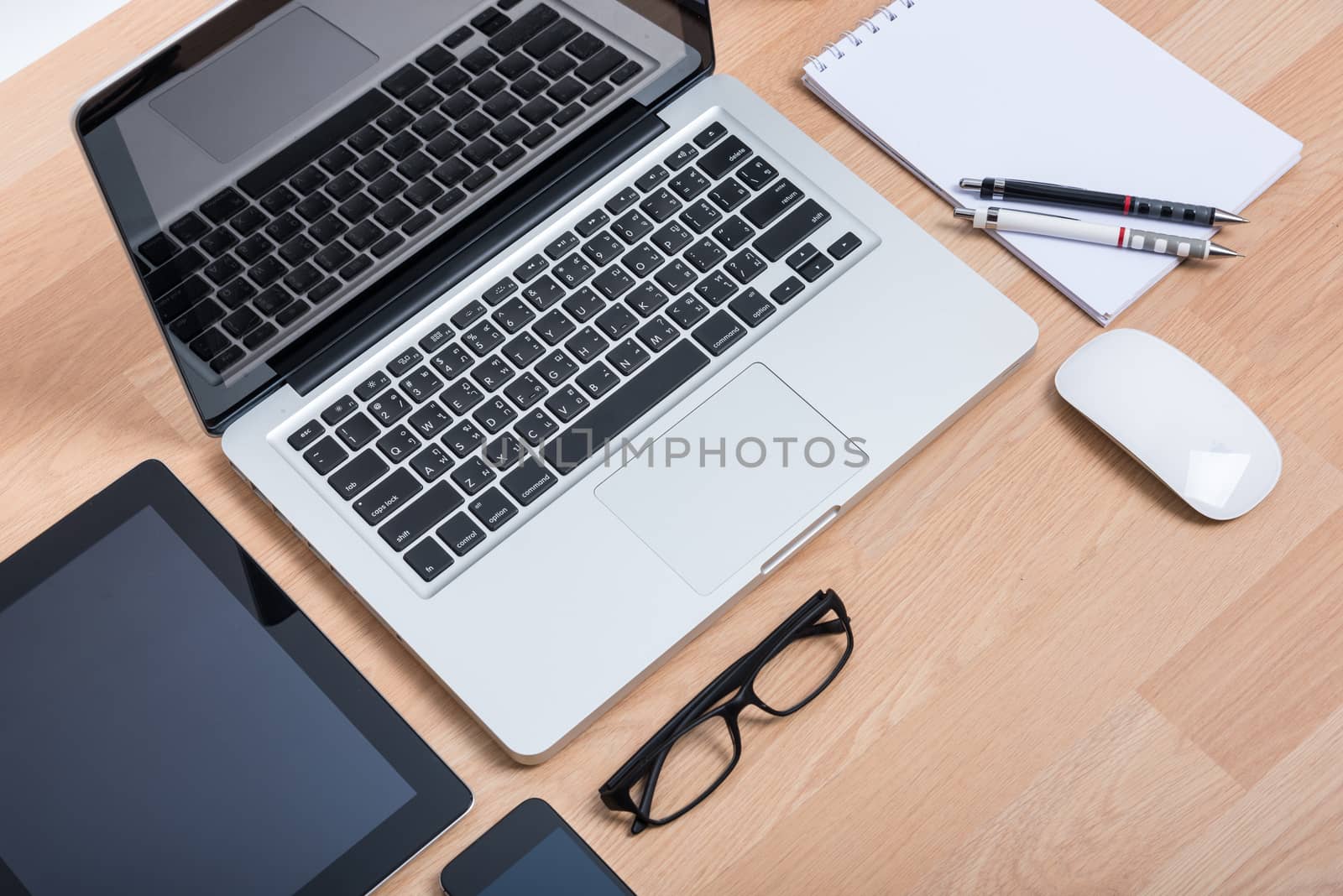 Top view open laptop with digital tablet and white smartphone on wooden desk