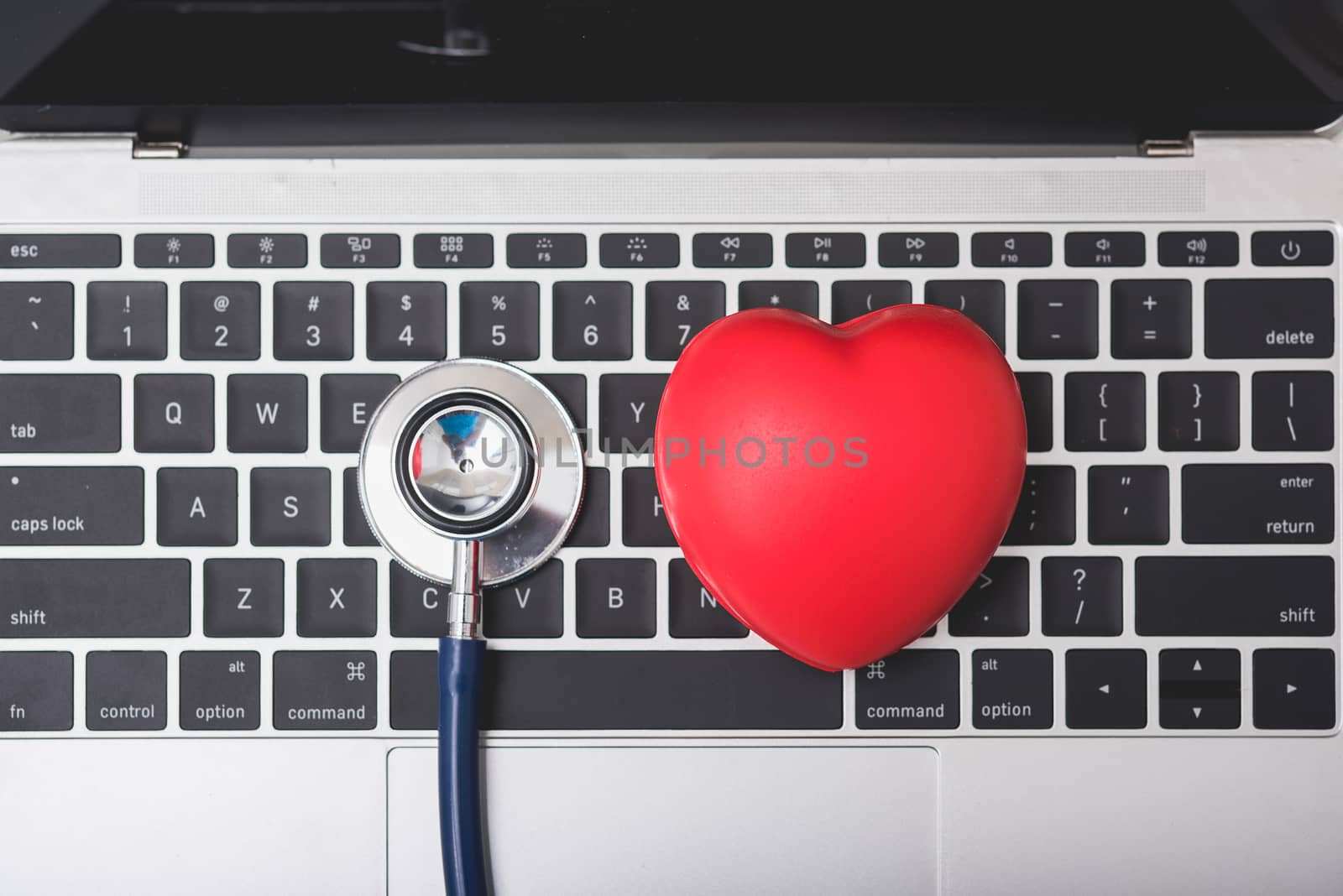 Health stethoscope and red heart on keyboard of laptop computer, medical concept