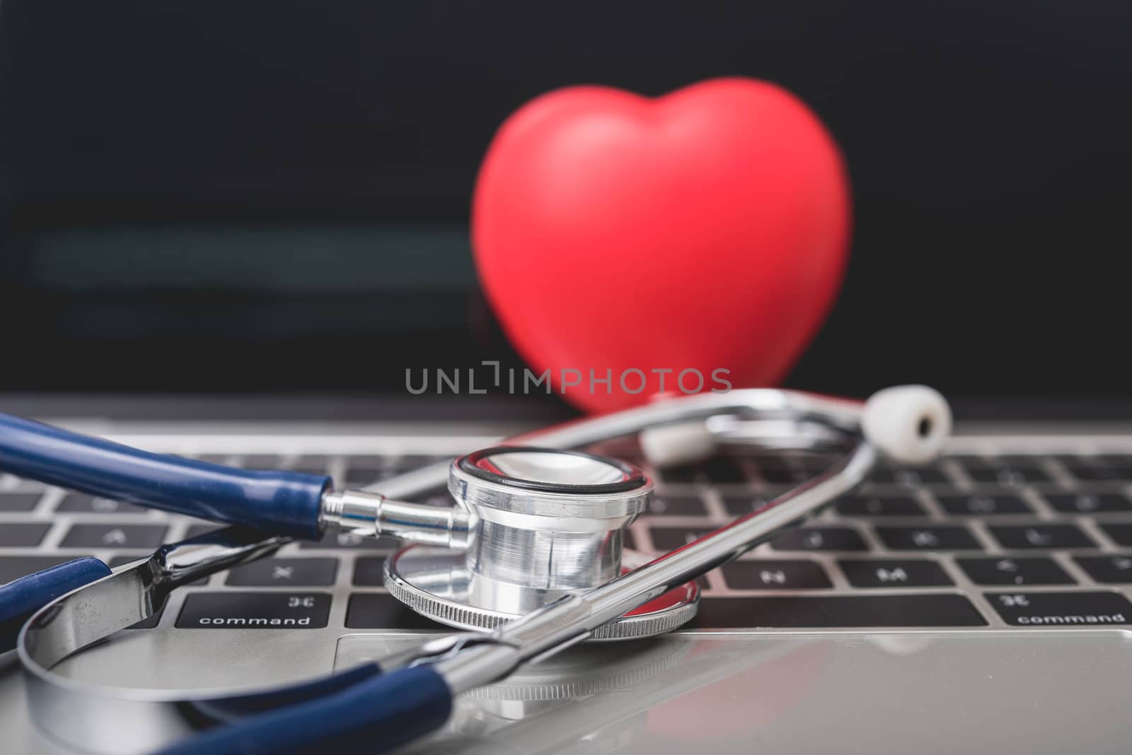 Health stethoscope and red heart on keyboard of laptop computer, medical concept