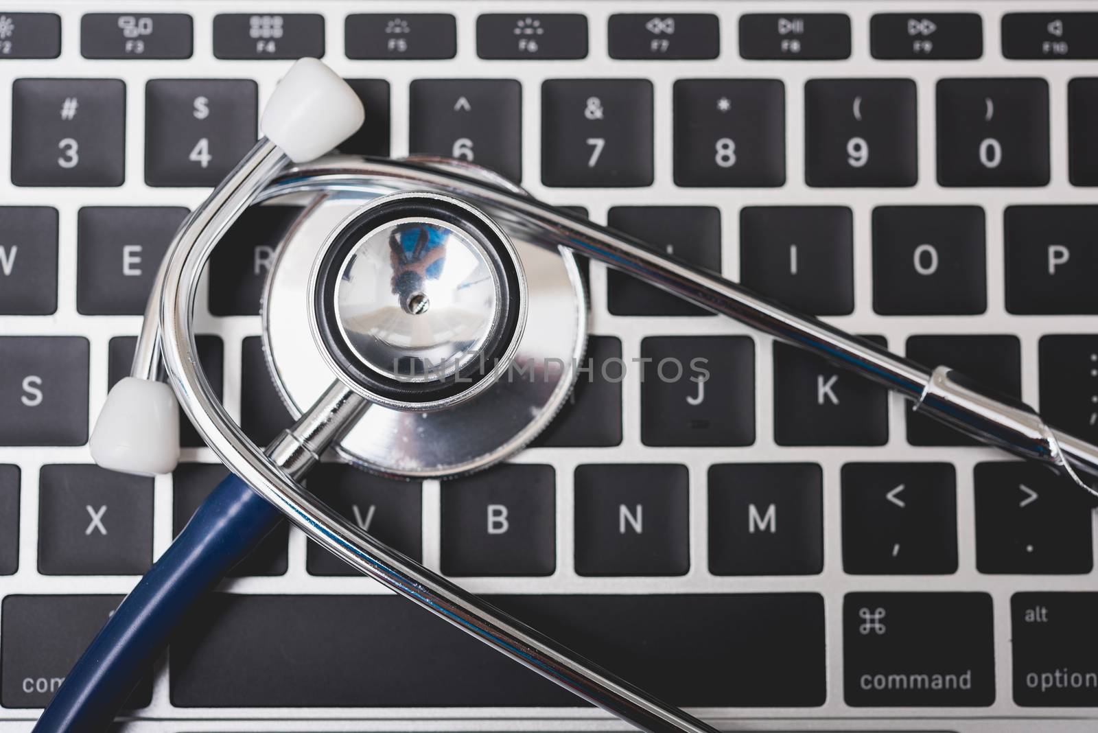 Health stethoscope on keyboard of laptop computer, medical concept