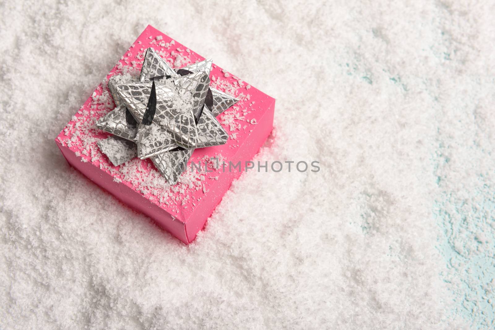 christmas presents nicely decorated with bows and feathers in snow. view from above