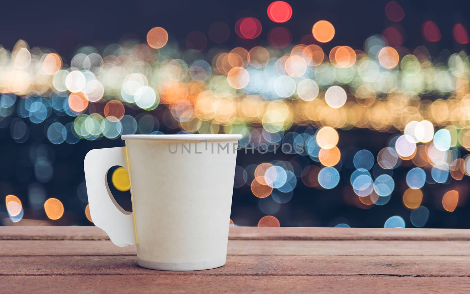Paper cup coffee on the wooden table with bokeh background
