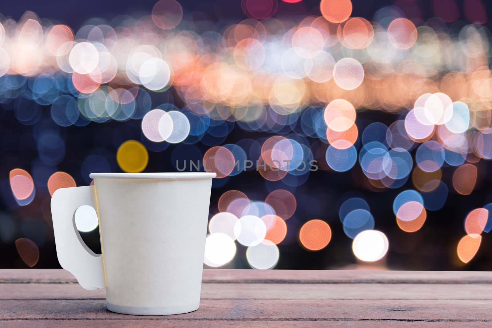 Paper cup coffee on the wooden table with bokeh background