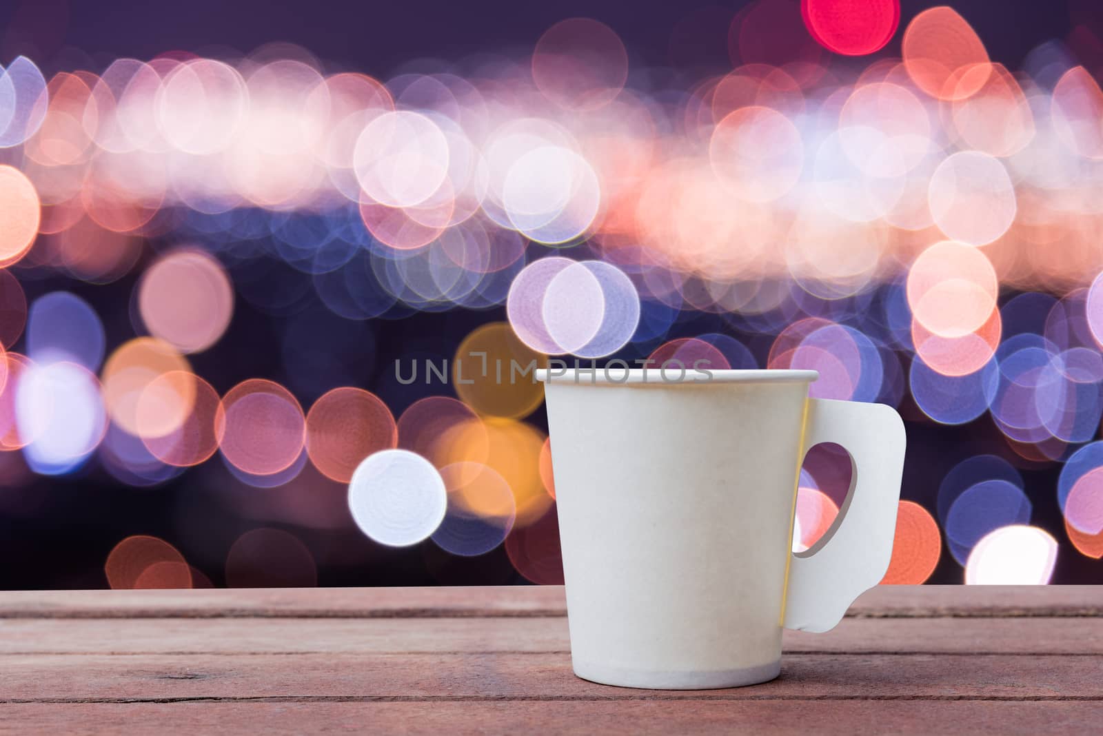 Paper cup coffee on the wooden table with bokeh background
