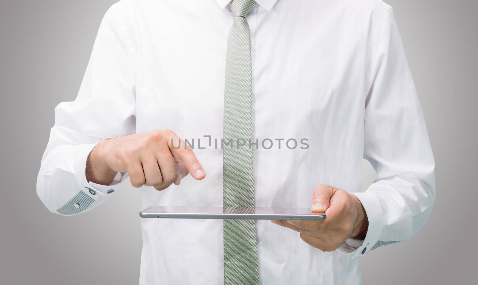 Businessman standing posture hand holding blank tablet isolated on over gray background