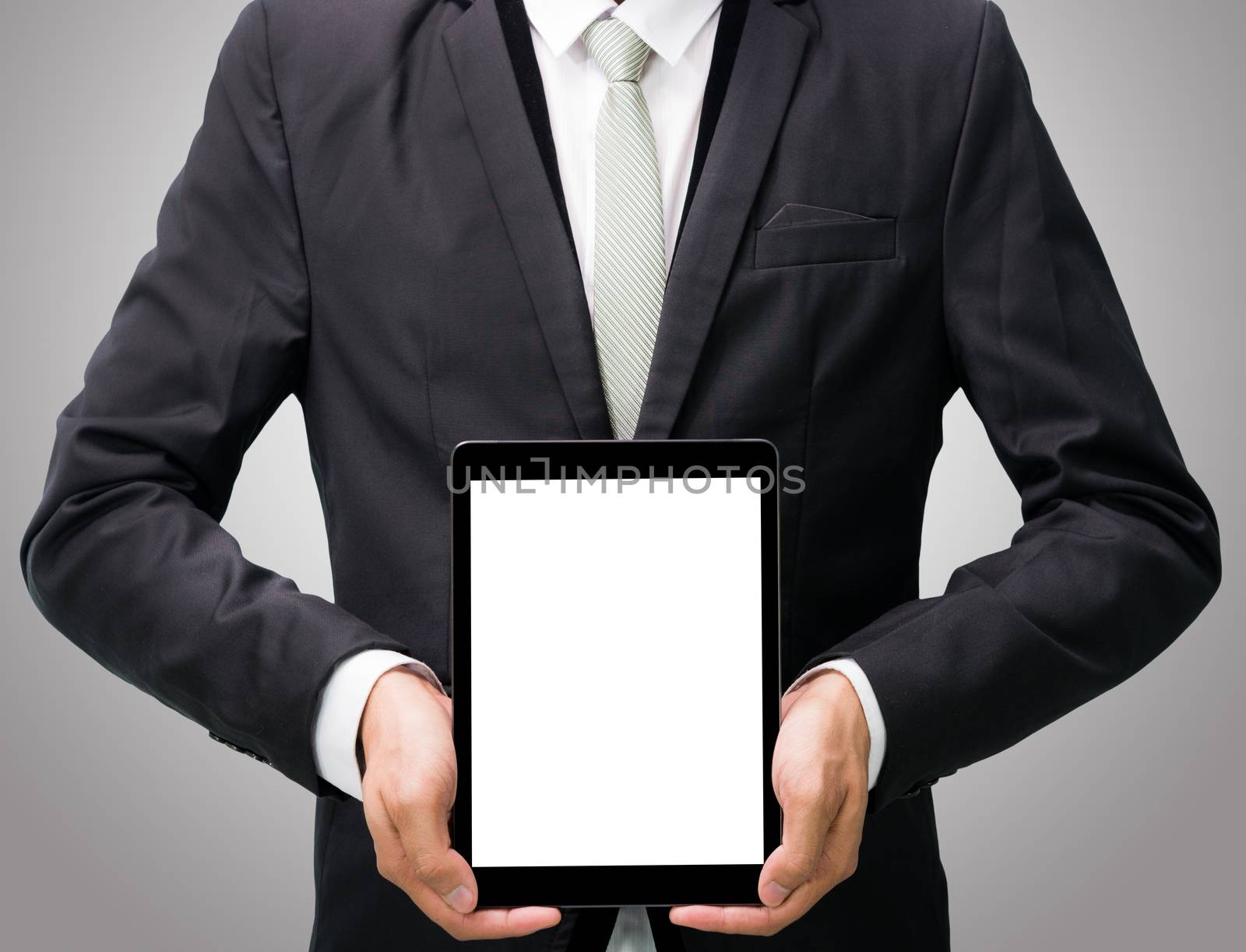 Businessman standing posture hand holding blank tablet isolated on over gray background