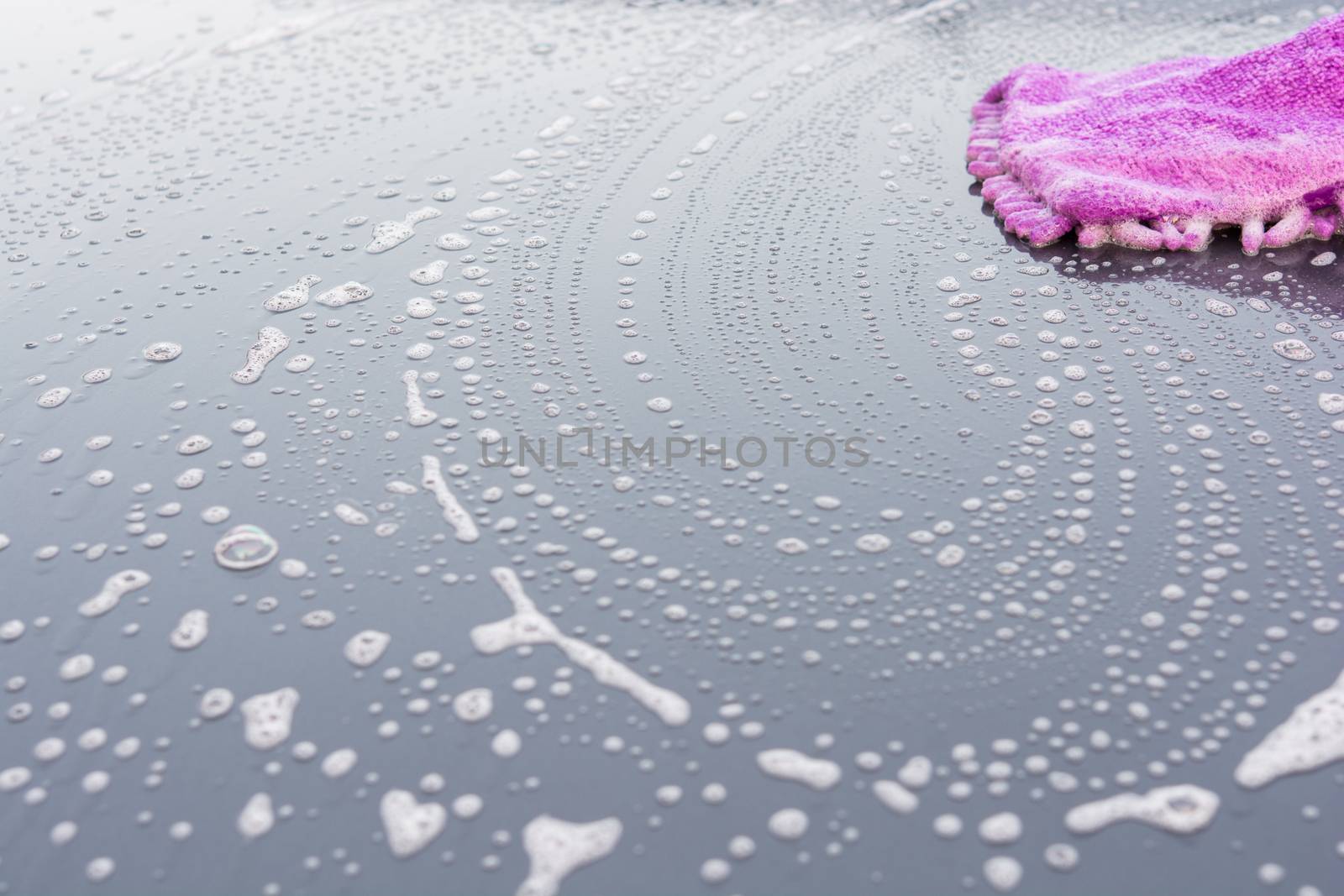Closeup cleaning his car using gloves car wash gray color