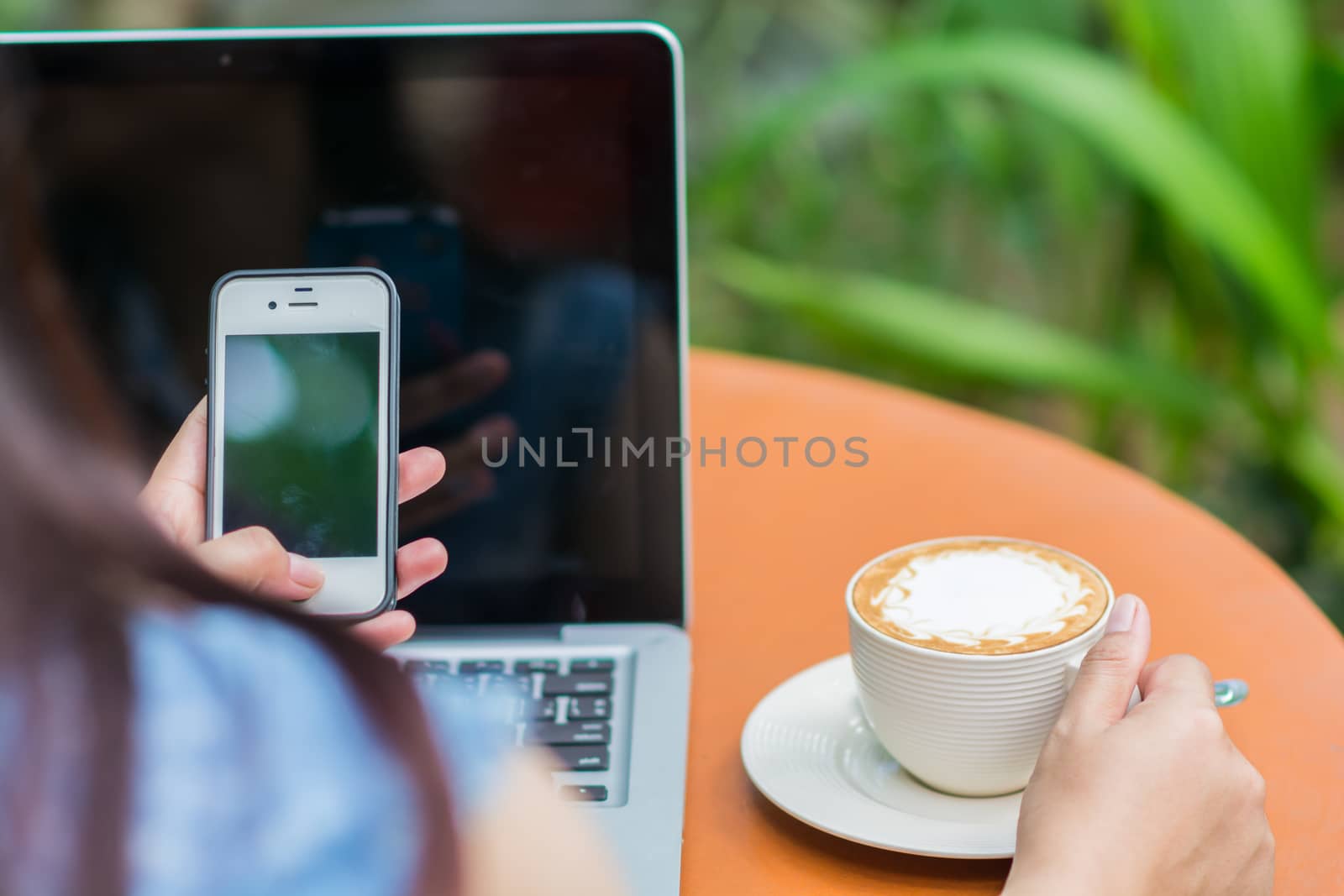 Woman hands typing on laptop outdoors in cafe