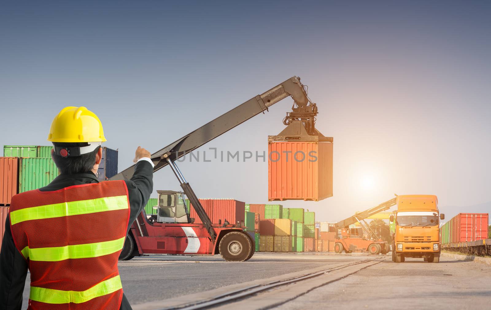 Foreman control forklift uploading truck with fork loader, man in safety uniform