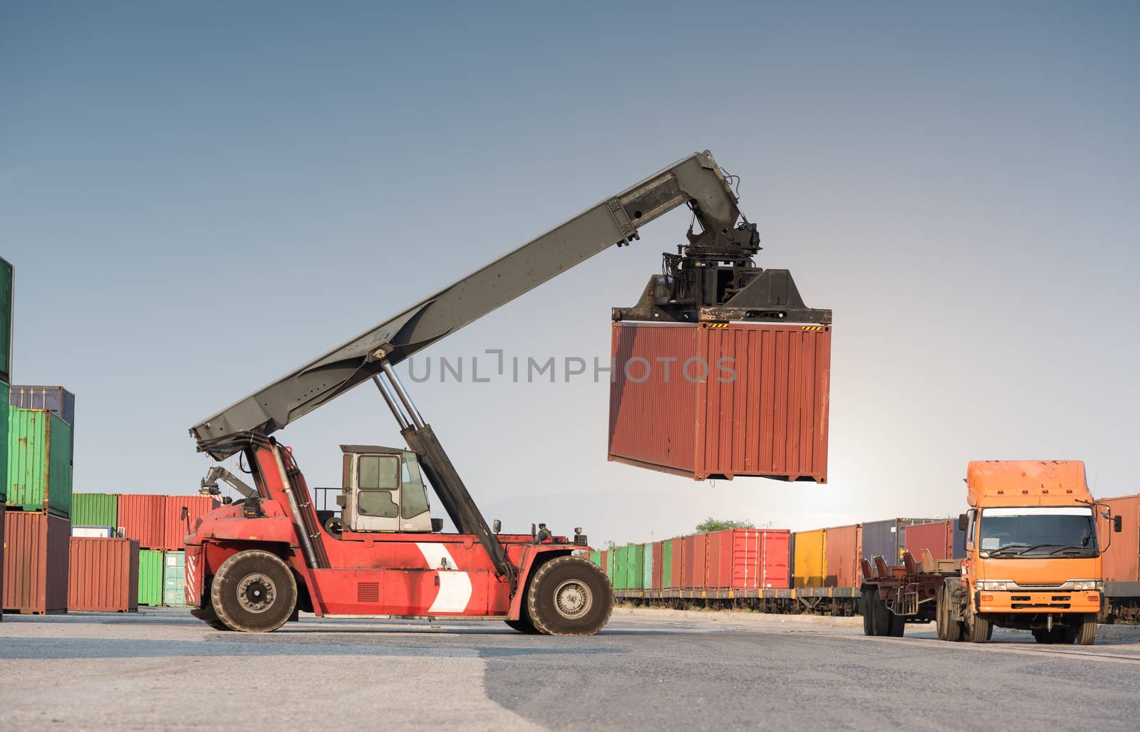 forklift handling container loading box from freight train to the truck