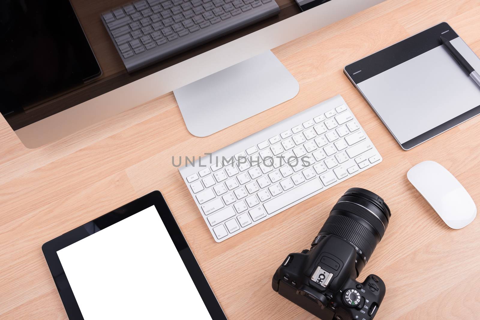 DSLR digital camera with tablet and computer PC on wooden dask table