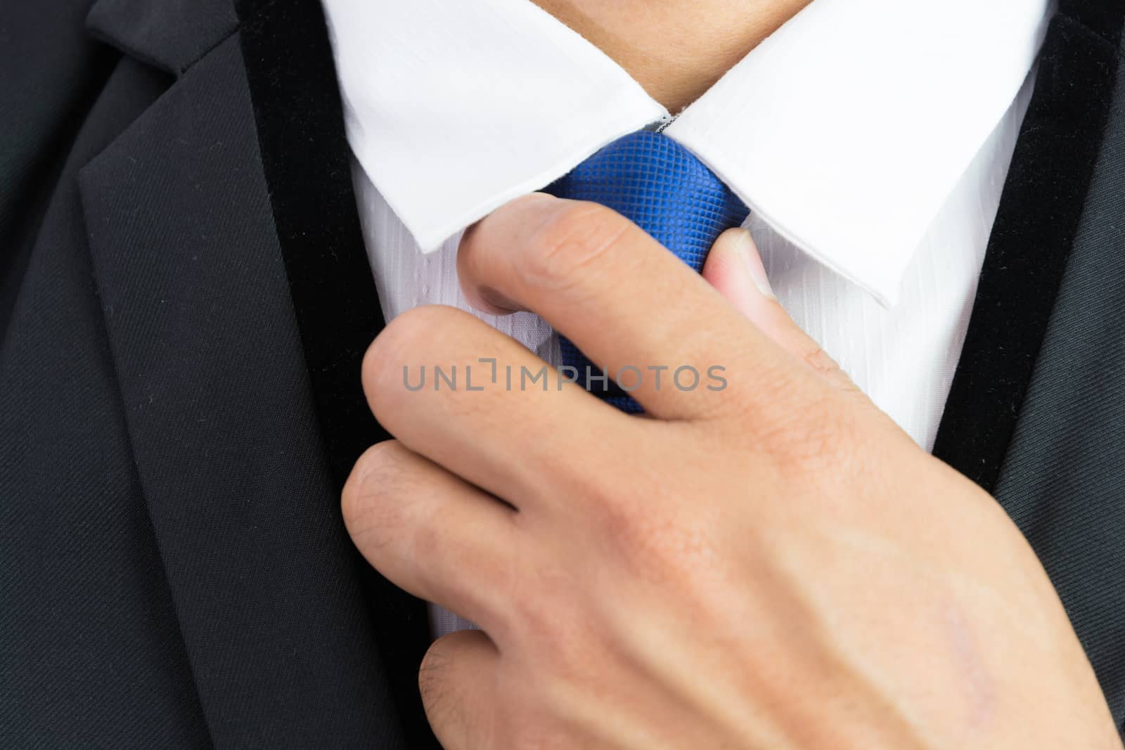 Businessman adjusting necktie isolated on over white background