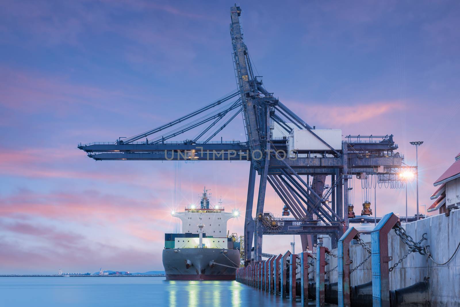 Container Cargo freight ship by crane bridge, logistics harbor at sunrise