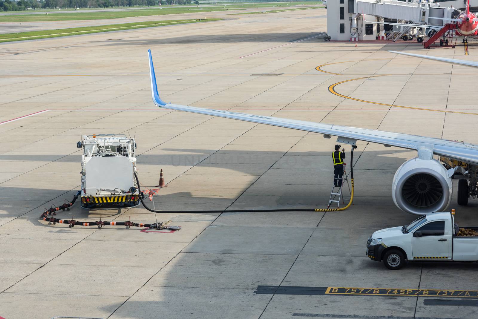 Airport man worker service refuelling the aircraft, runway