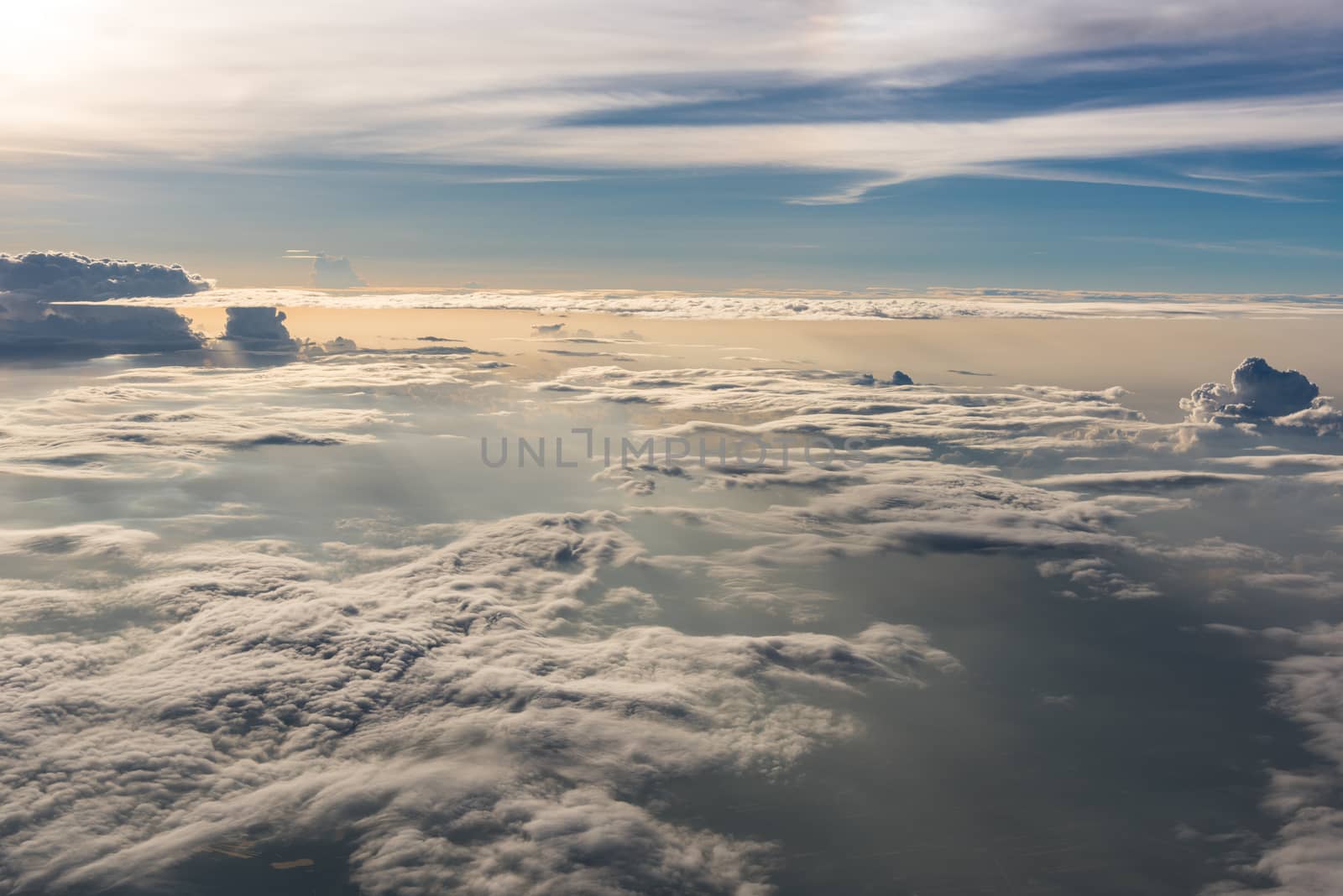 Many cloud in Flying above sunrise, view from outside airplane