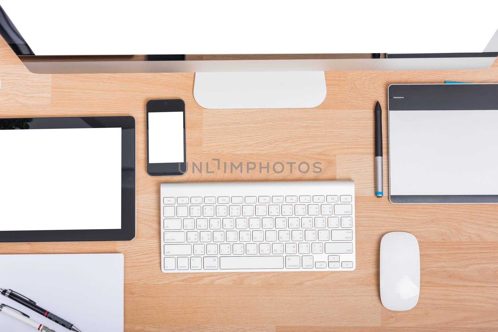 Top view computer PC monitor and keyboard with Phone, magic mouse and tablet on wooden desk