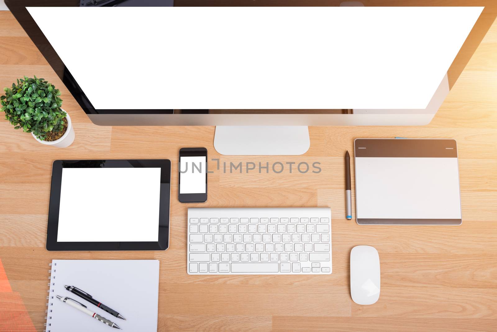 Top view monitor computer PC, keyboard, Phone, magic mouse and tablet on wooden desk