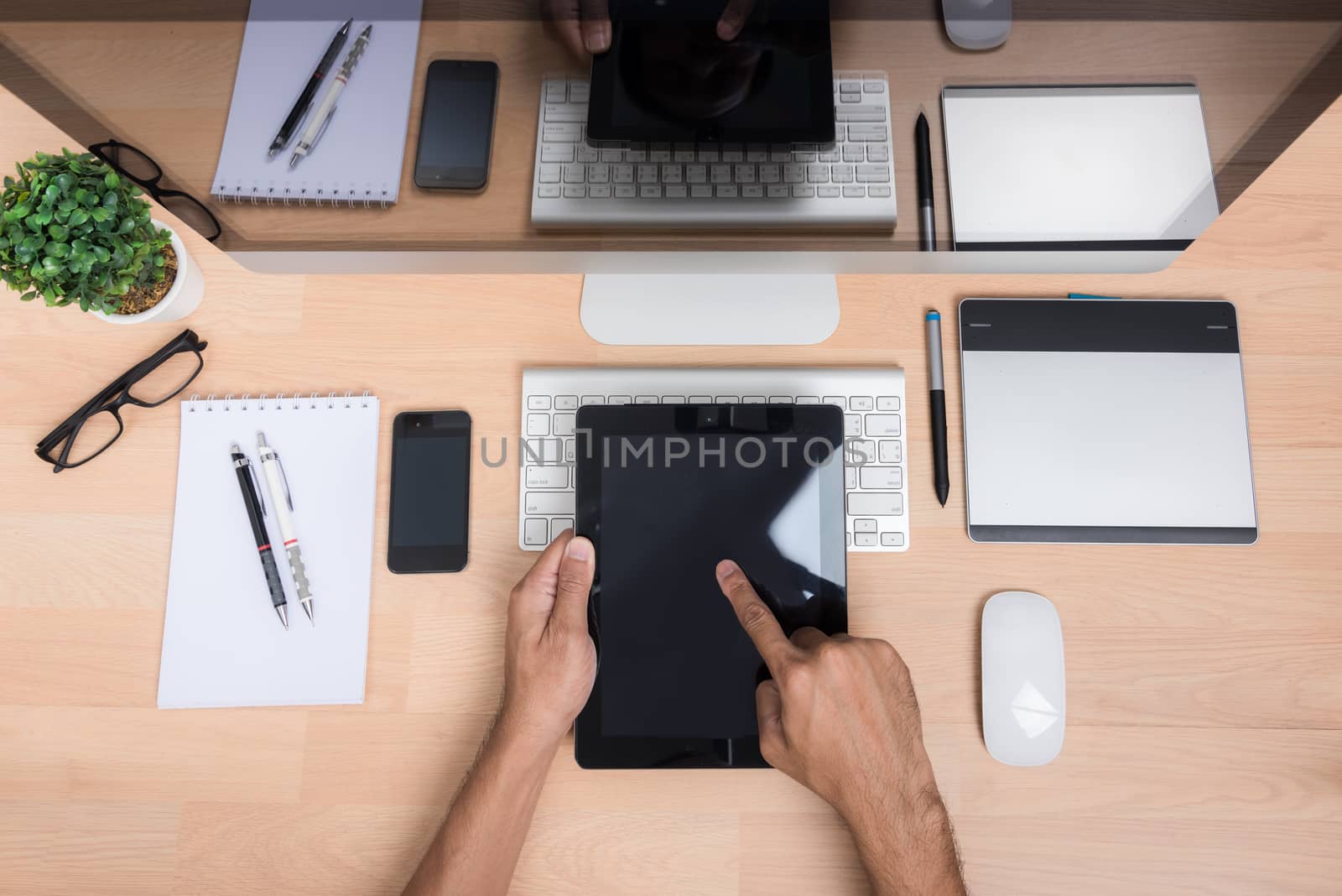 Top view office hand working with Tablet, mobile phone, keyboard mouse, computer PC, on wooden desk