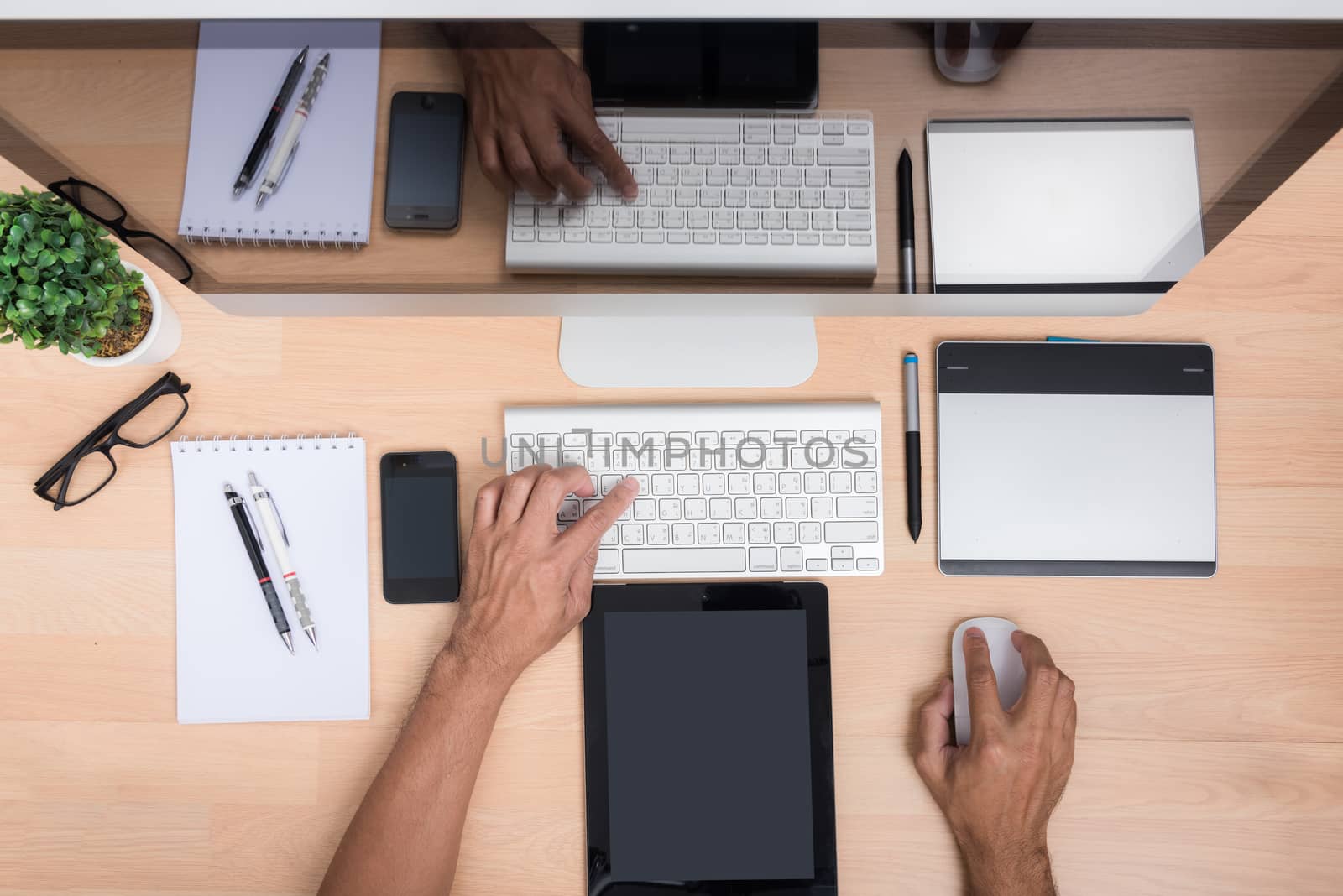 Top view office hand working with Tablet, mobile phone, keyboard mouse, computer PC, on wooden desk