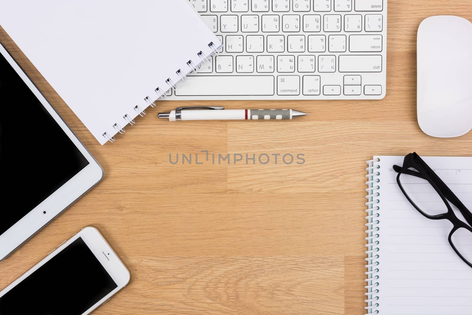 Business desk with a keyboard, mouse and pen by Sorapop