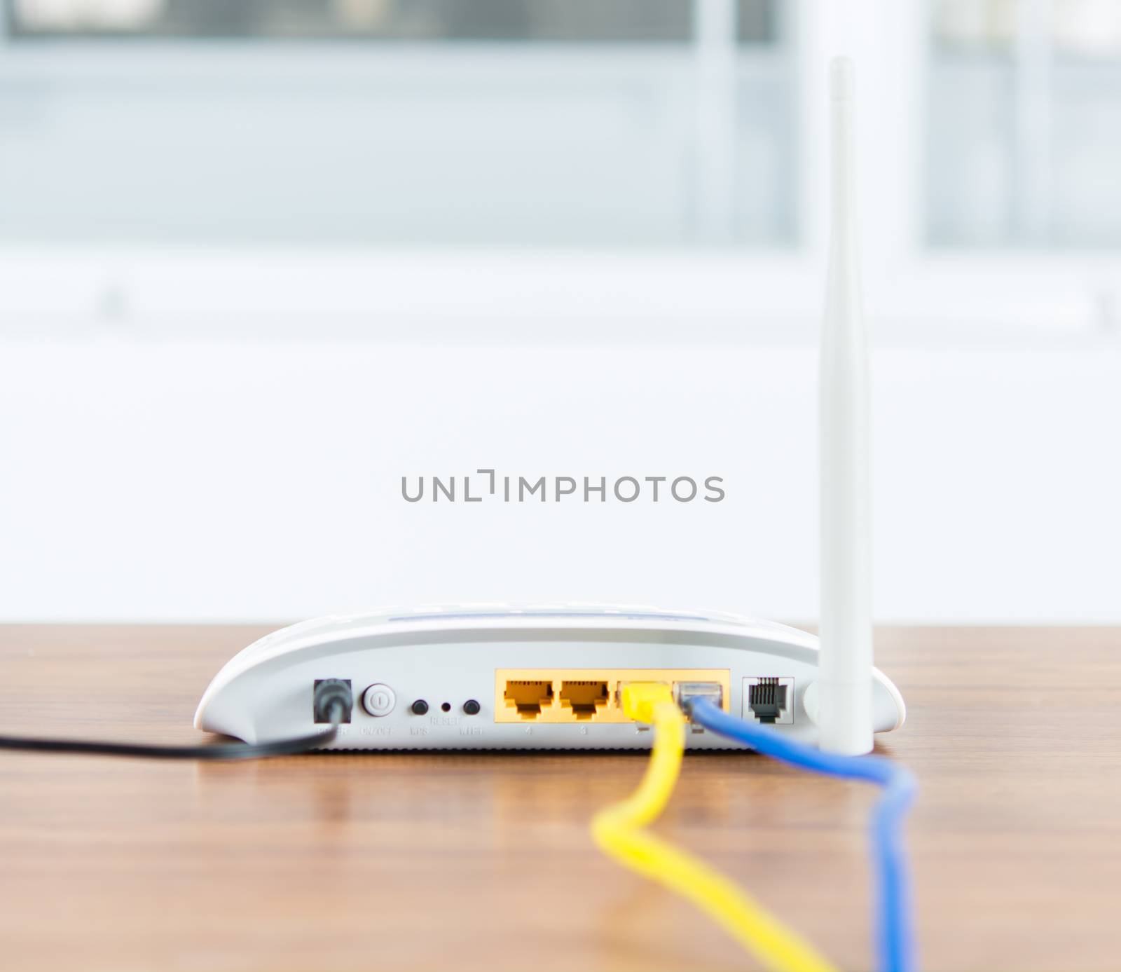 Wireless modem router network hub with cable connect on wooden table in the room