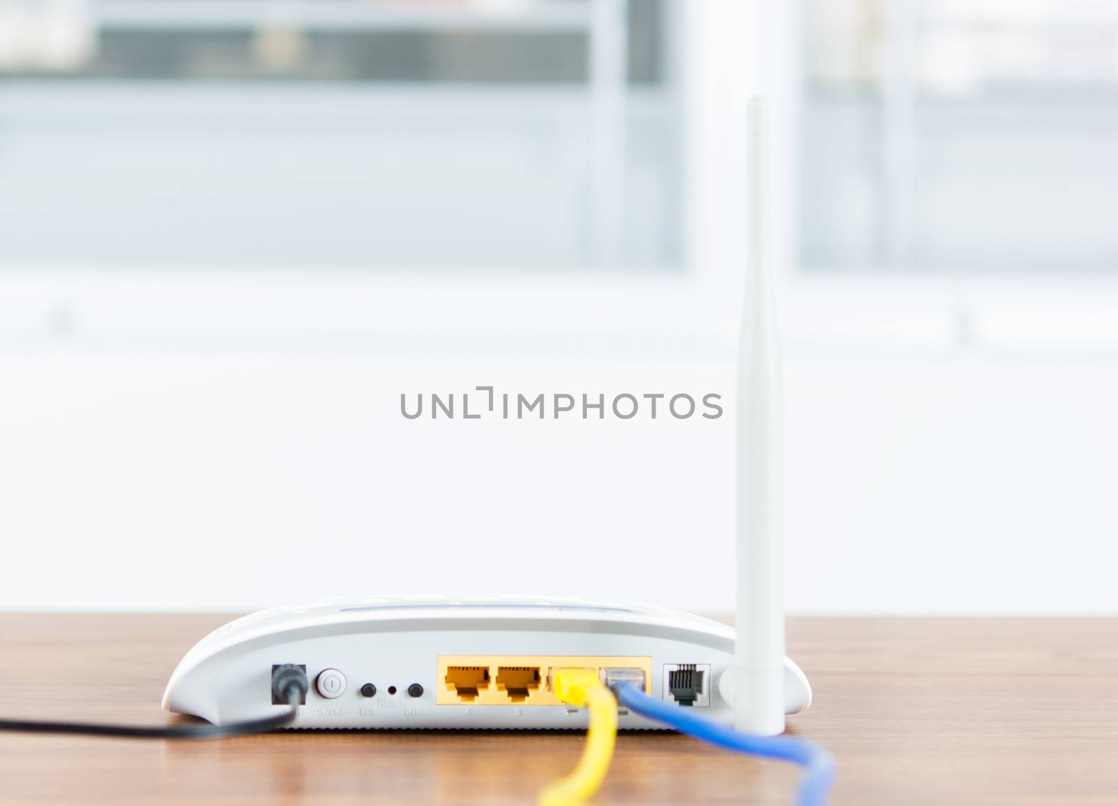 Wireless modem router network hub with cable connect on wooden table in the room
