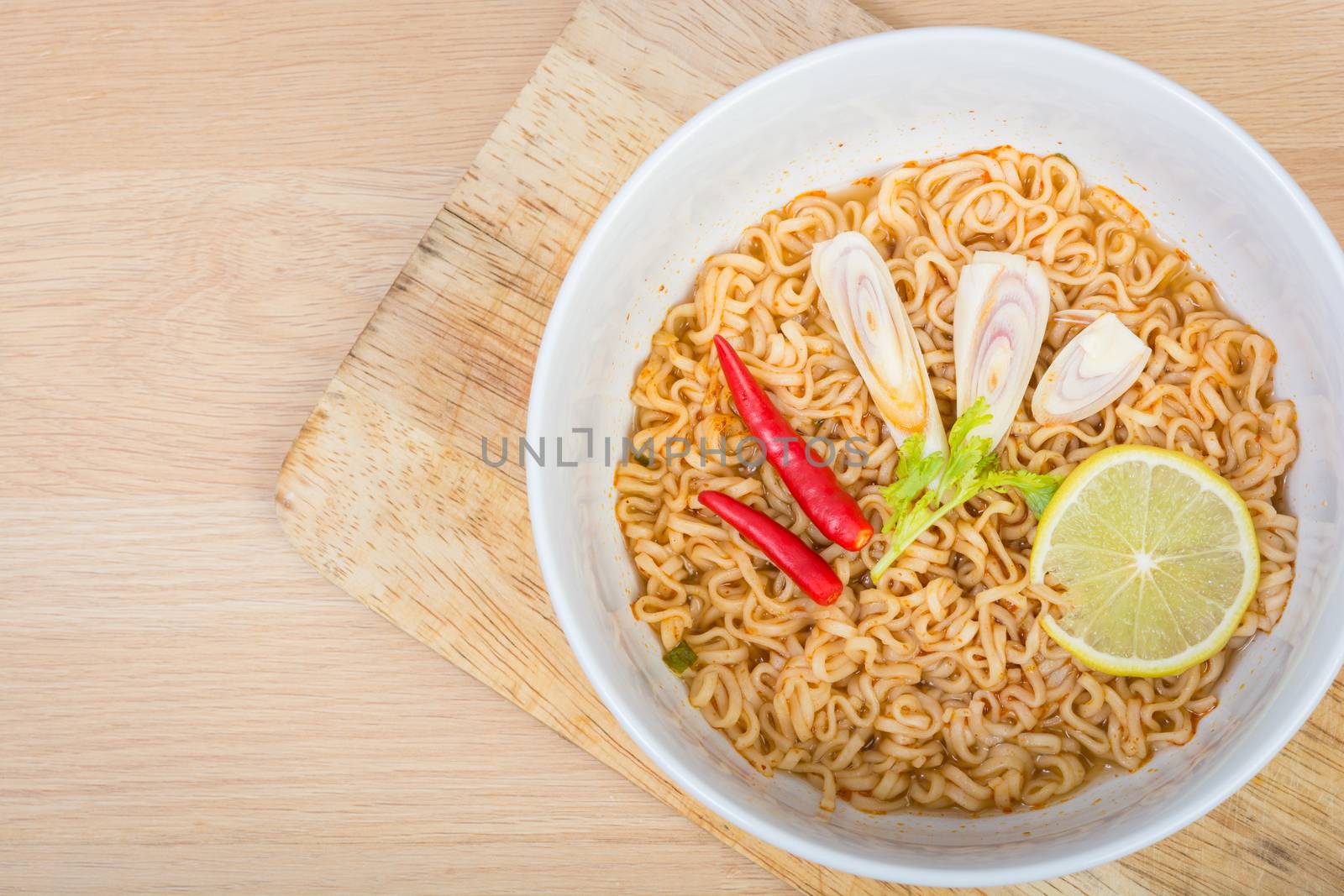 Hot and spicy instant noodle on wooden background